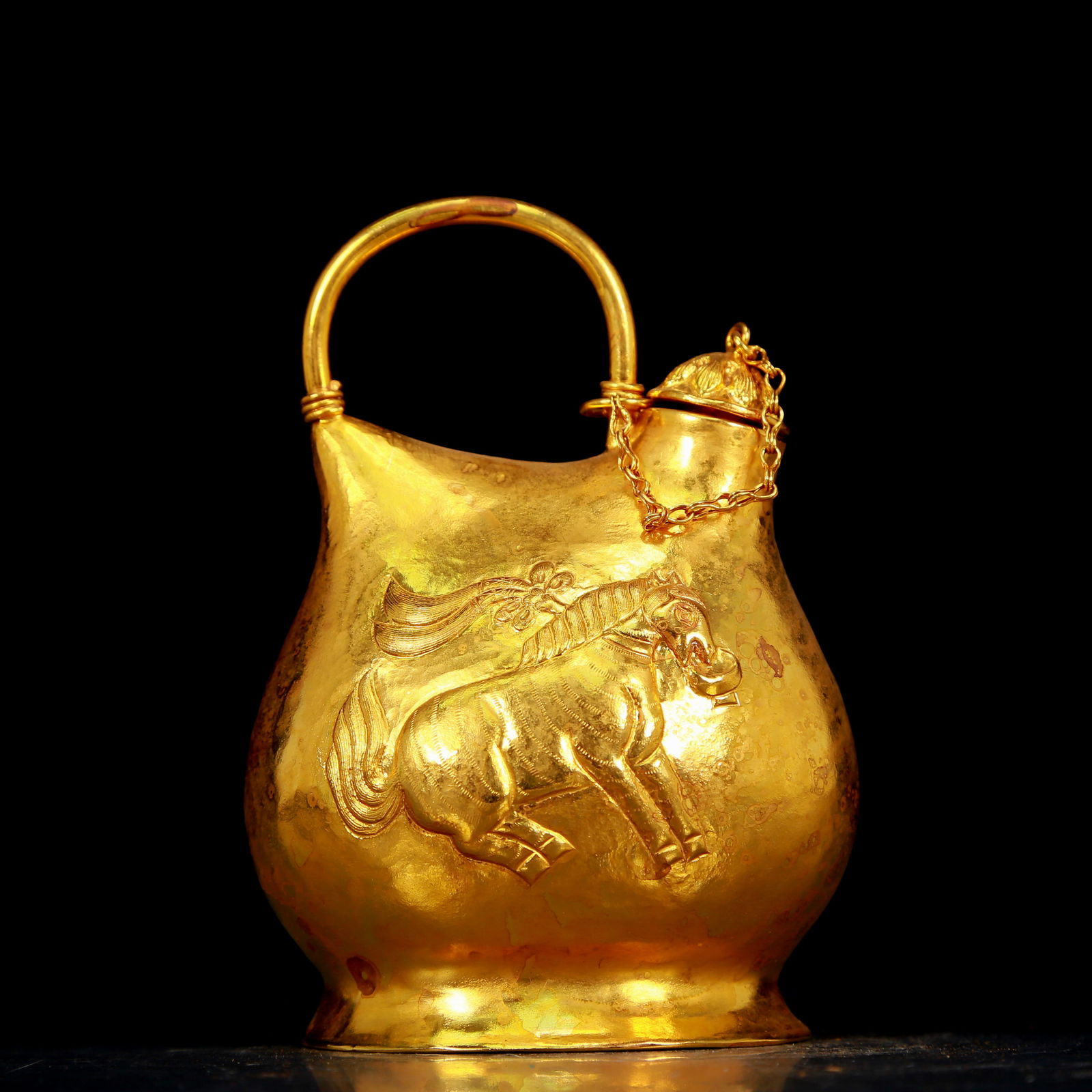 An exquisite gilt bronze hip flask with horse pattern: An exquisite gilt bronze horse-patterned wine pot, Tang Dynasty, China, Zhenguan four-character mark. The surface has been carefully carved, vividly demonstrating the superb skills of the craftsman. I