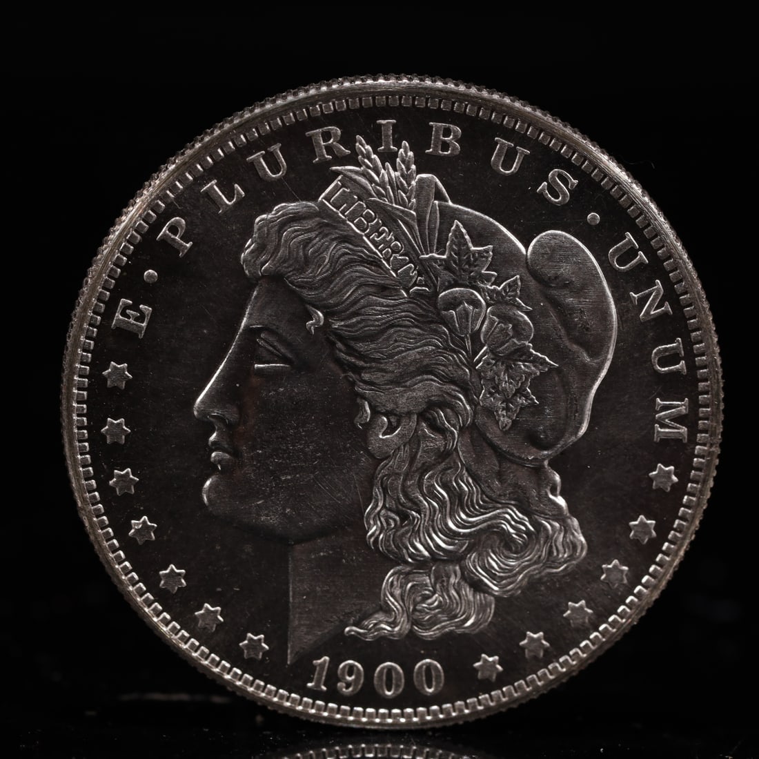 USA Morgan Dollar 1900 Coin: Obv: profile bust with date below and E PLURIBUS UNUM legend and stars around. Rev: eagle with In God we trust above within wreath with UNITED STATES OF AMERICA ONE DOLLAR legend. IN GOD WE TRUST /