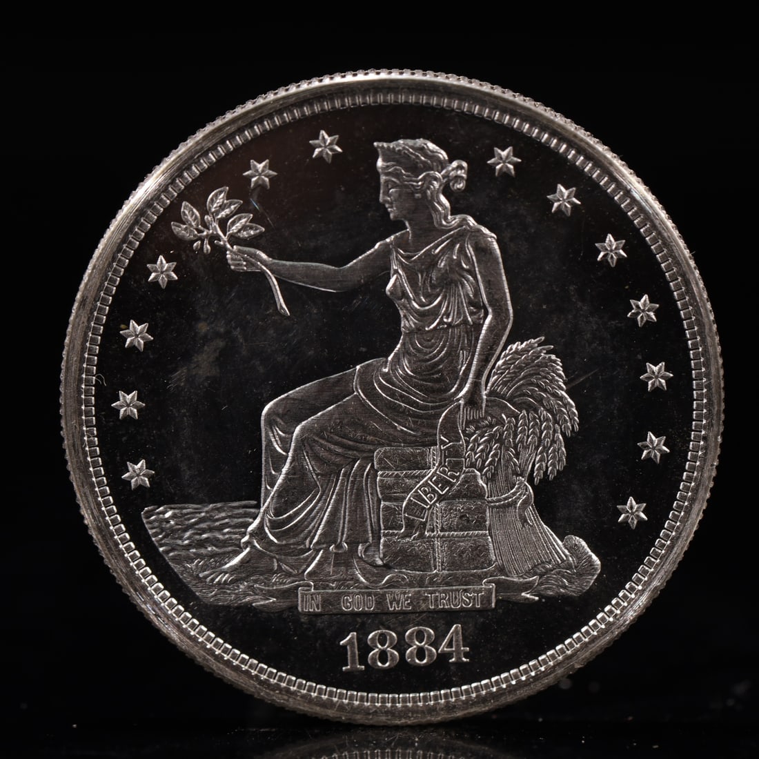 USA Trade Dollar 1884 Coin: American coin. Obverse: Liberty seated on a pedestal facing the sea to the left holding olive branches surrounded by 13 stars. IN GOD WE TRUST / LIBERTY / 1884. Reverse: An eagle holding branches