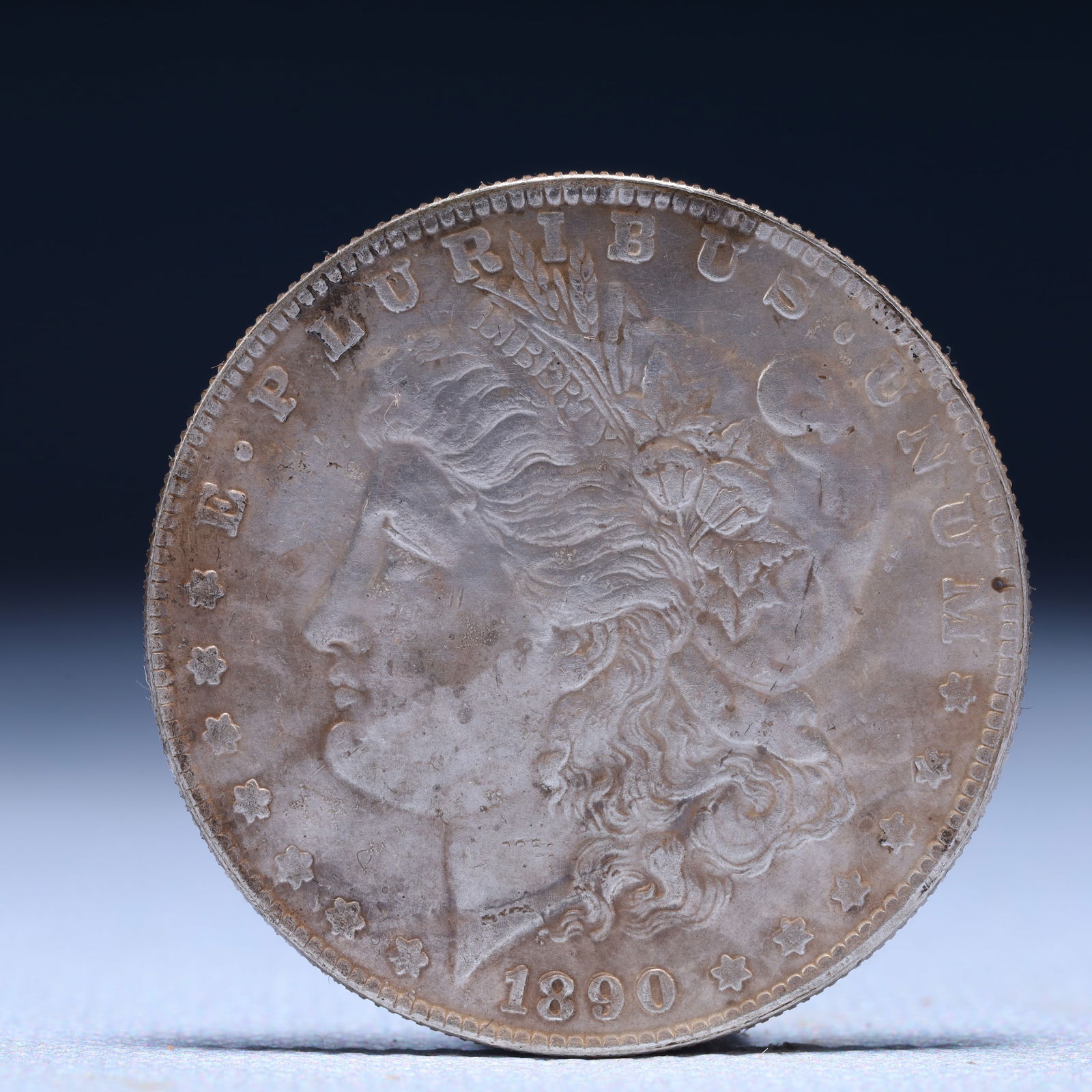 USA Morgan Dollar 1890 Coin: Obv: profile bust with date below and E PLURIBUS UNUM legend and stars around. Rev: eagle with In God we trust above within wreath with UNITED STATES OF AMERICA ONE DOLLAR legend. IN GOD WE TRUST /