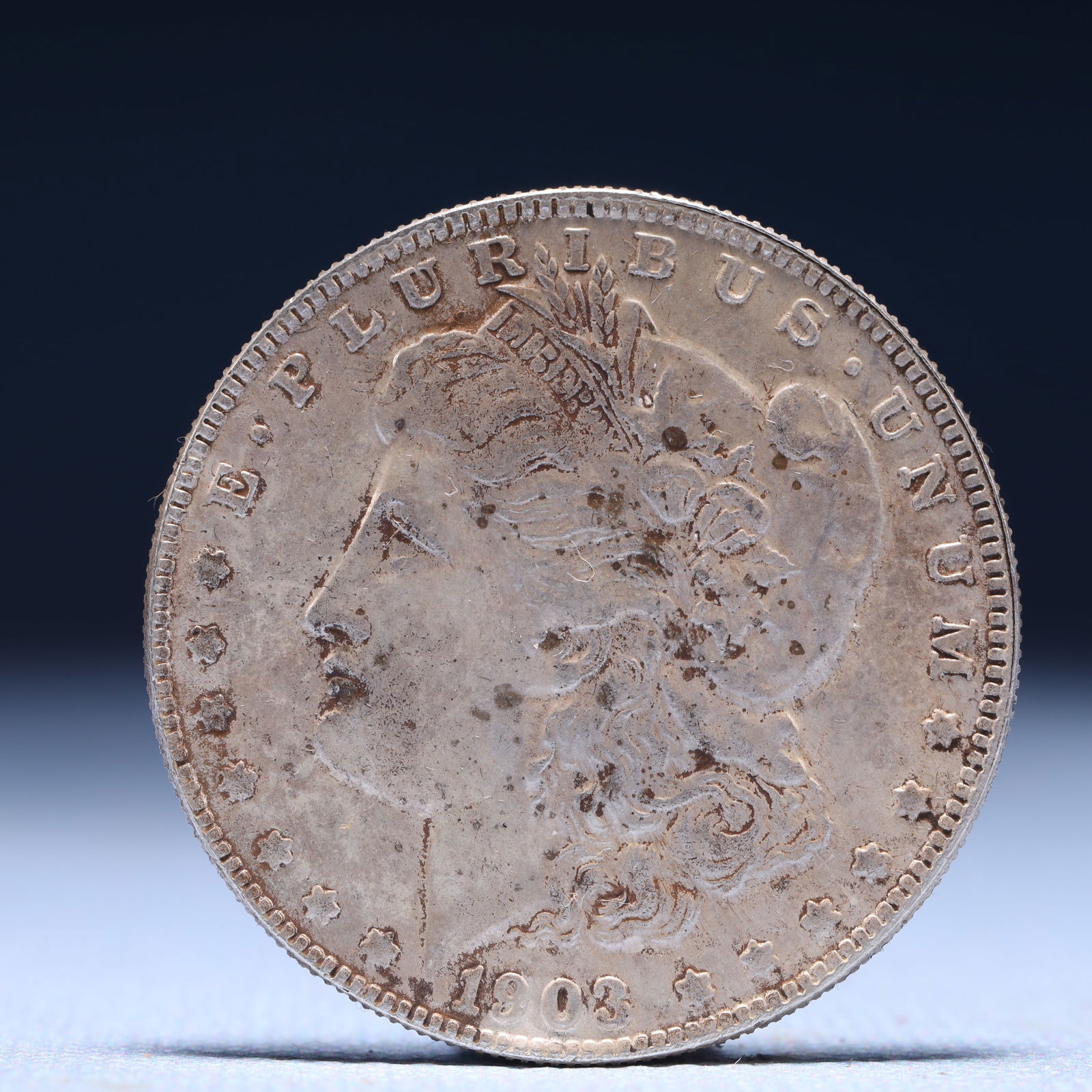 USA Morgan Dollar 1903 Coin: Obv: profile bust with date below and E PLURIBUS UNUM legend and stars around. Rev: eagle with In God we trust above within wreath with UNITED STATES OF AMERICA ONE DOLLAR legend. IN GOD WE TRUST /