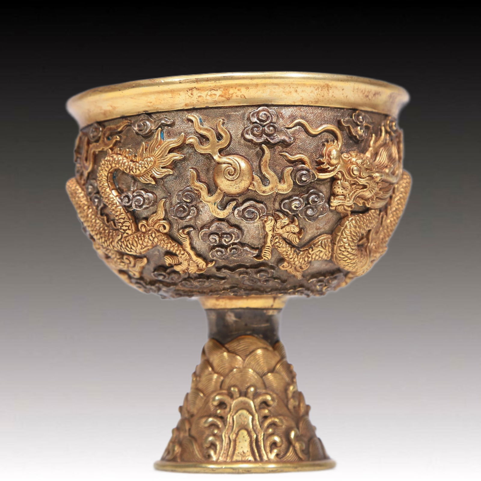 A Brilliant Gilt-Bronze Silver 'Dragon' Cup: A Brilliant Gilt-Bronze Silver 'Dragon' Cup. Supported on a subtly splayed foot, body cast with scaly, sinuous dragons writhing and pursuing a flaming pearl. Chinese Qing Dynasty. Size:4.3inx4.7in.