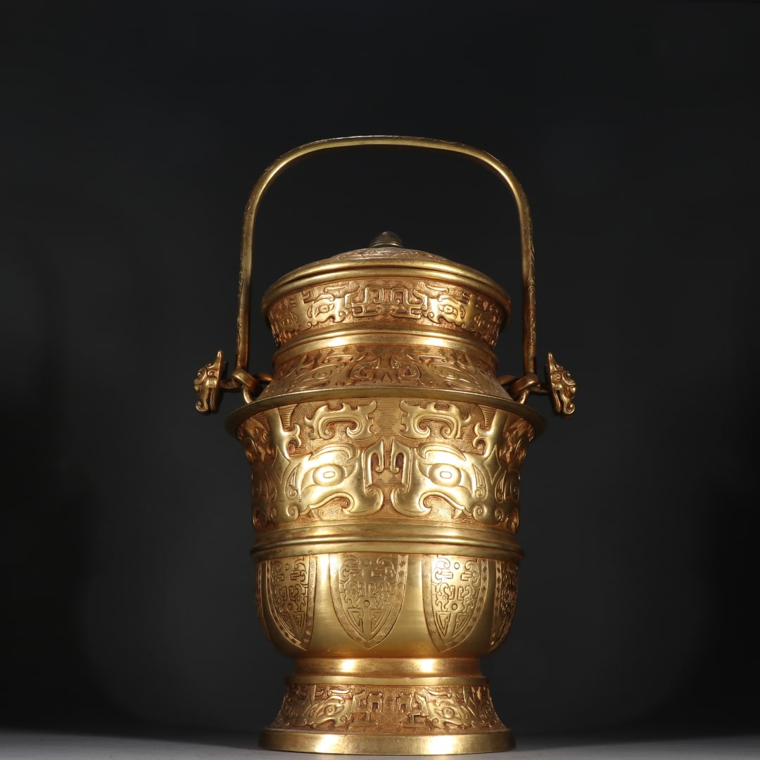 An Exquisite Gilt Bronze Beast-Face Pattern Ewer: An Exquisite Gilt Bronze Beast-Face Pattern Ewer Qing Dynasty, China Size:15inx9.3in Weight:2615.3g铜鎏金兽面纹提梁卣 中国清