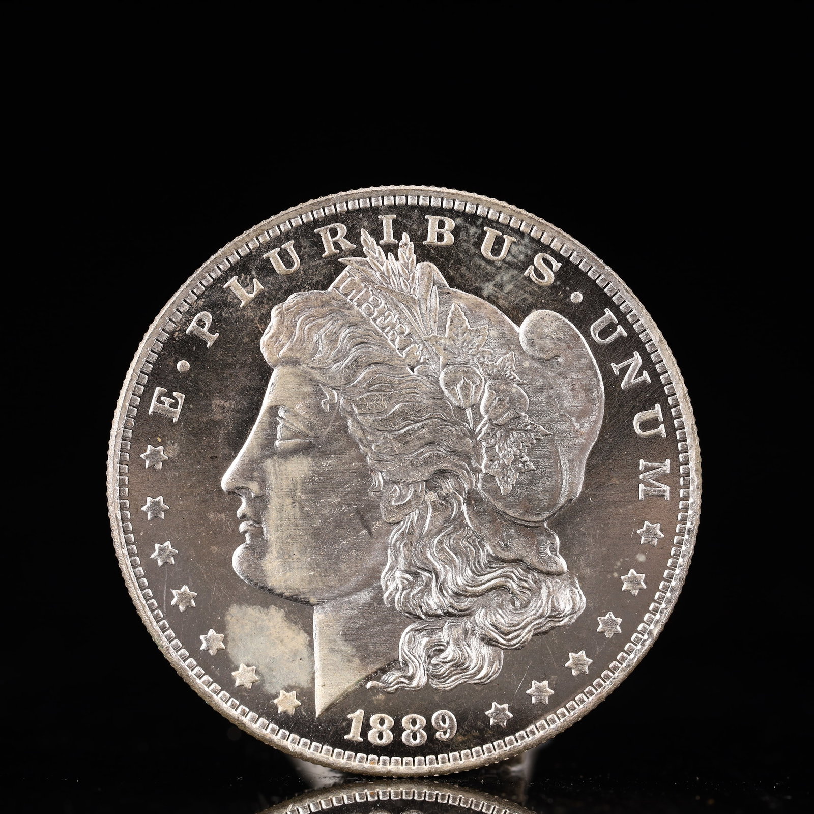USA Morgan Dollar 1889 Coin: Obv: profile bust with date below and E PLURIBUS UNUM legend and stars around. Rev: eagle with In God we trust above within wreath with UNITED STATES OF AMERICA ONE DOLLAR legend. IN GOD WE TRUST / LI