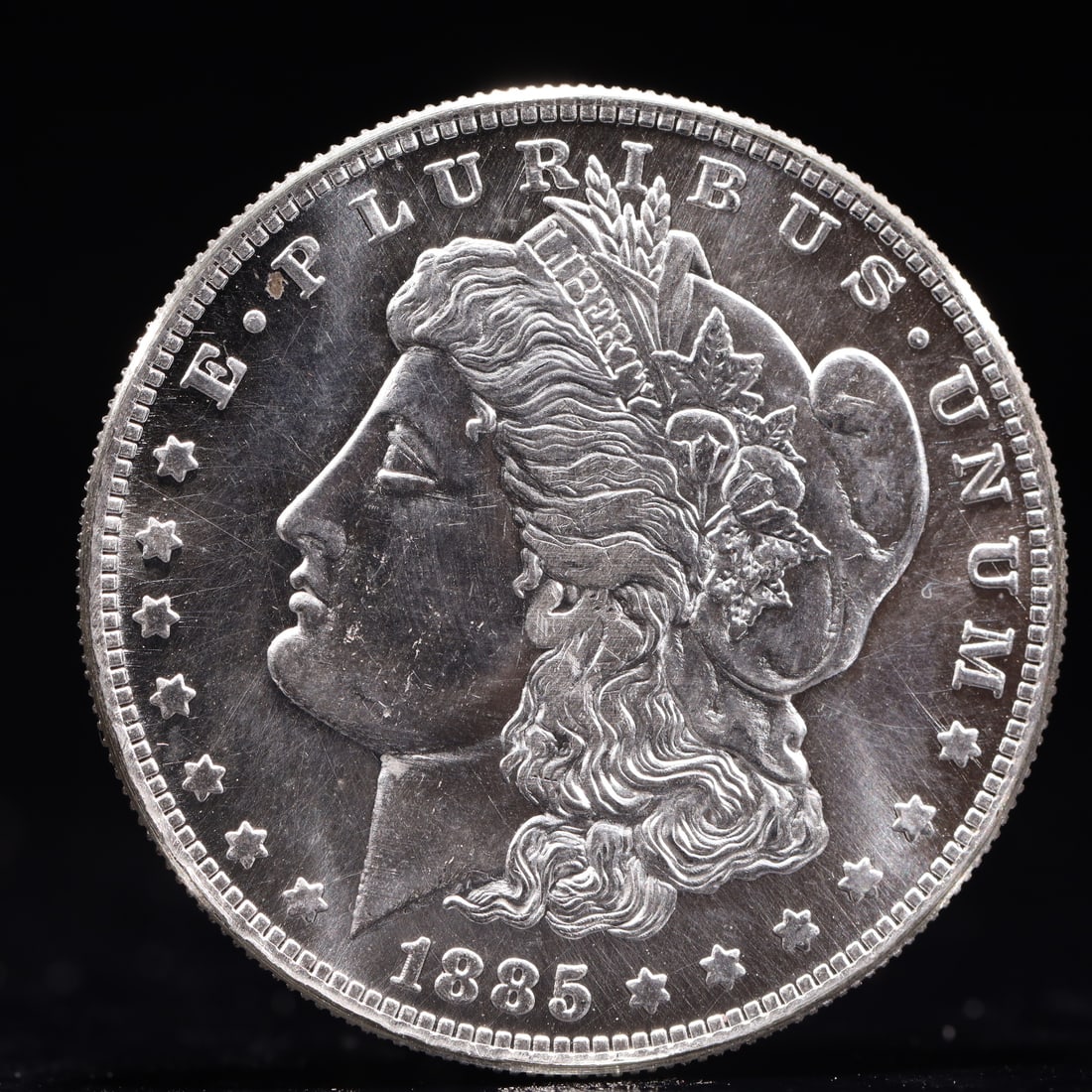 USA Morgan Dollar 1885 Coin: Obv: profile bust with date below and E PLURIBUS UNUM legend and stars around. Rev: eagle with In God we trust above within wreath with UNITED STATES OF AMERICA ONE DOLLAR legend. IN GOD WE TRUST /