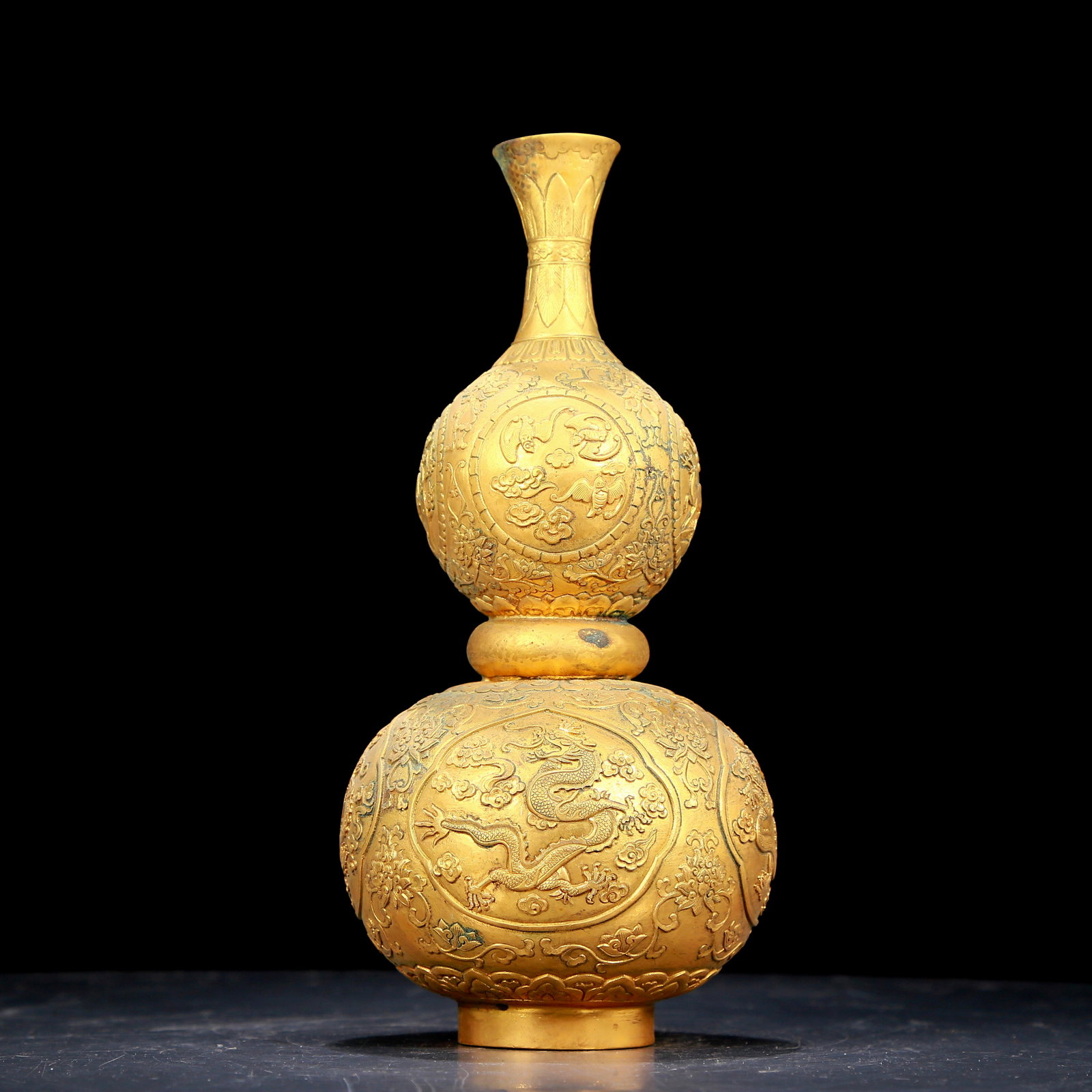 An exquisite gilt bronze gourd vase with auspicious clouds and dragon patterns: An exquisite gilt bronze gourd vase with auspicious clouds and dragon patterns, Qing Dynasty, China. The surface has been carefully carved, vividly demonstrating the superb skills of the craftsmen. It