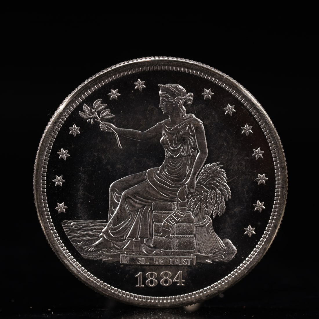 USA Trade Dollar 1884 Coin: American coin. Obverse: Liberty seated on a pedestal facing the sea to the left holding olive branches surrounded by 13 stars. IN GOD WE TRUST / LIBERTY / 1884. Reverse: An eagle holding branches with