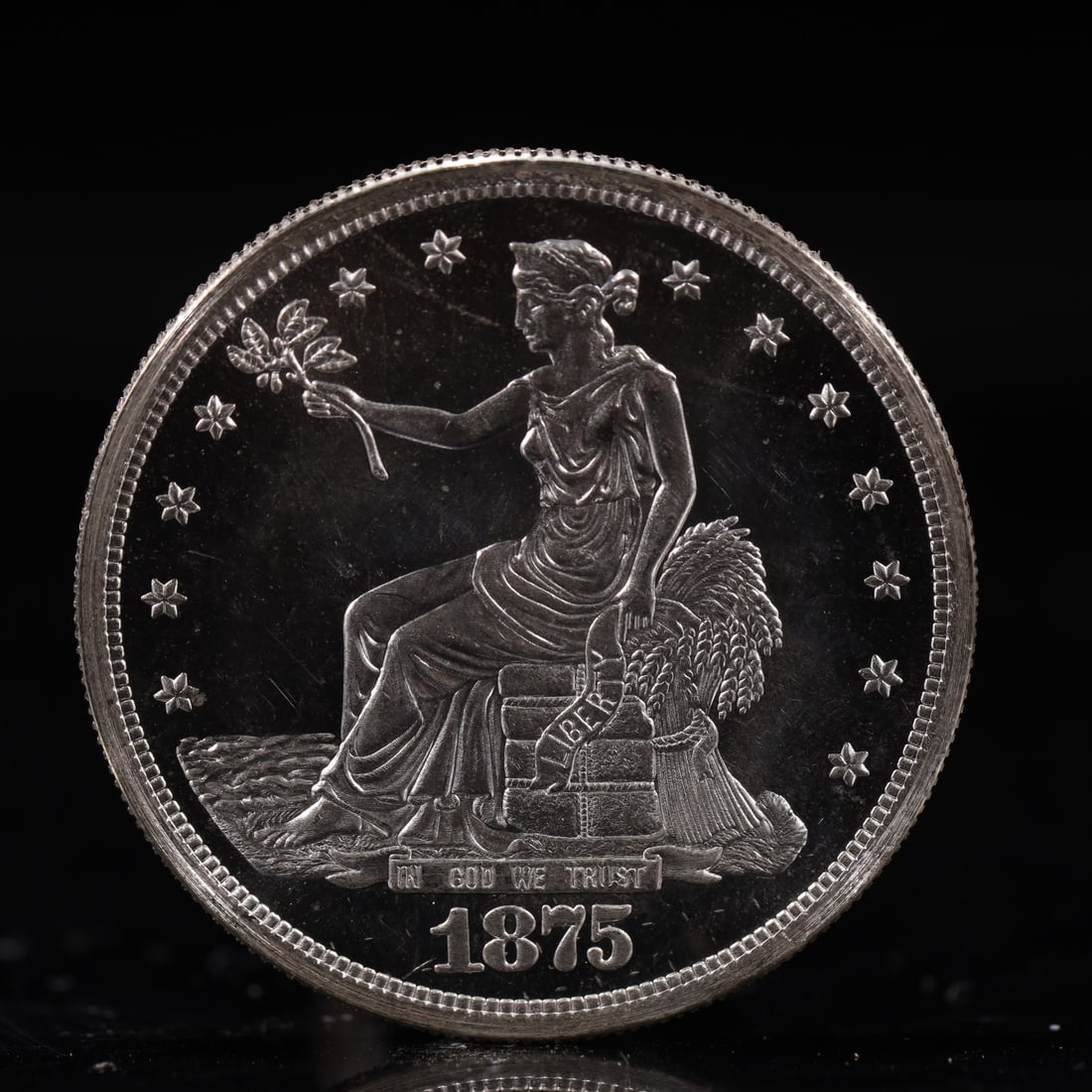 USA Trade Dollar 1875 Coin: American coin. Obverse: Liberty seated on a pedestal facing the sea to the left holding olive branches surrounded by 13 stars. IN GOD WE TRUST / LIBERTY / 1875. Reverse: An eagle holding branches with