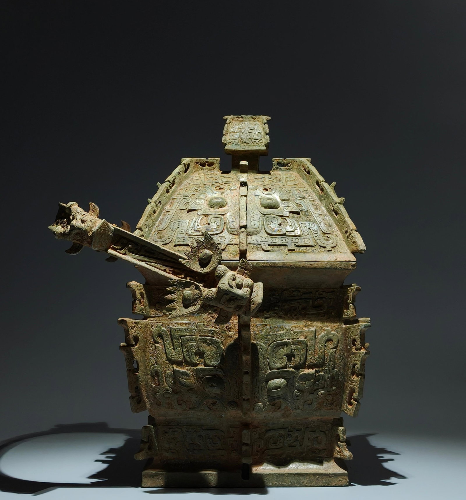 An Archaic Bronze Beast-Face Pattern Loop-Handled Pot: An Archaic Bronze Beast-Face Pattern Loop-Handled Pot,Sang Dynasty,China,Size:18.1inx12.6inx11.4in 青铜兽面纹提梁壶,中国商代