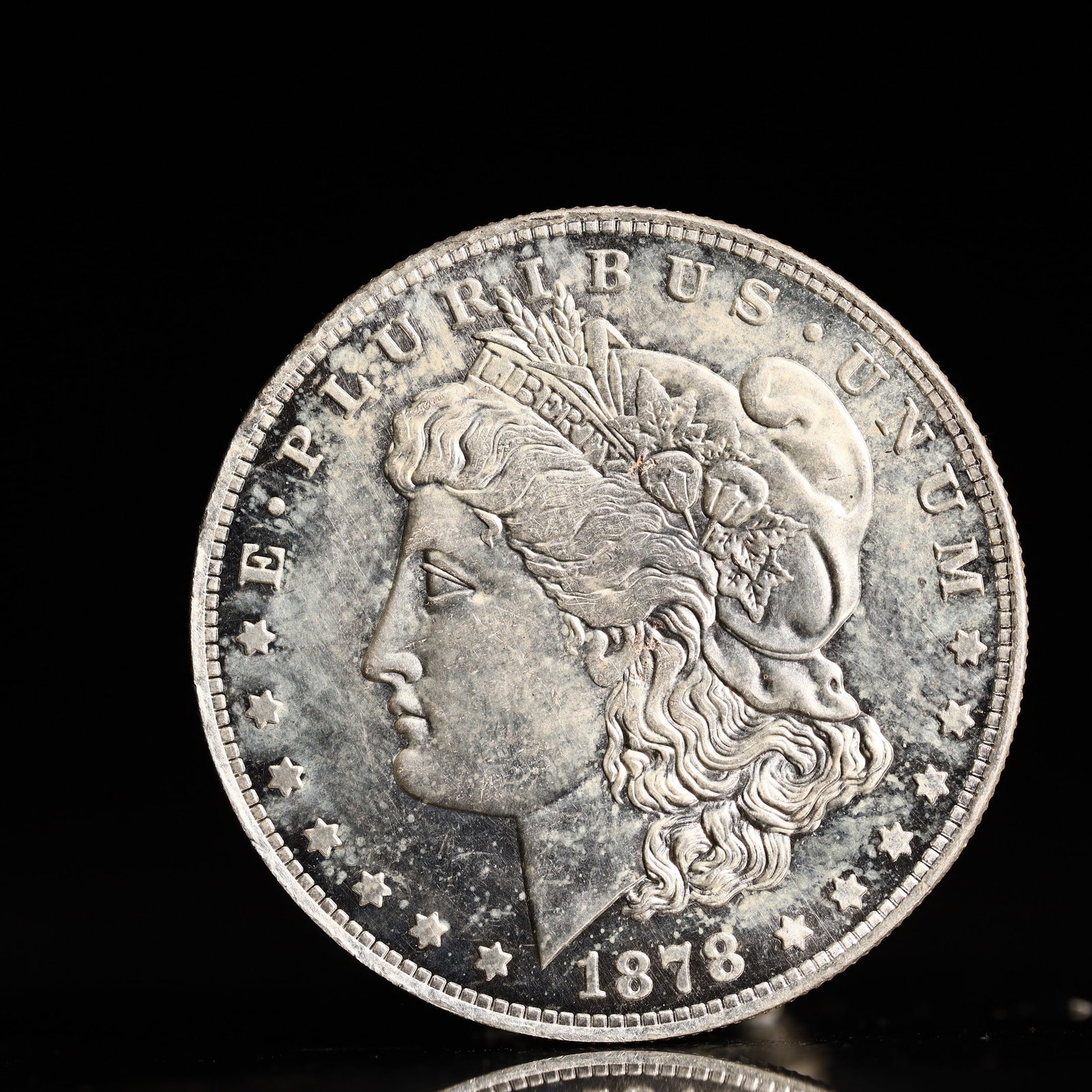 USA Morgan Dollar 1878 Coin: Obv: profile bust with date below and E PLURIBUS UNUM legend and stars around. Rev: eagle with In God we trust above within wreath with UNITED STATES OF AMERICA ONE DOLLAR legend. IN GOD WE TRUST / LI