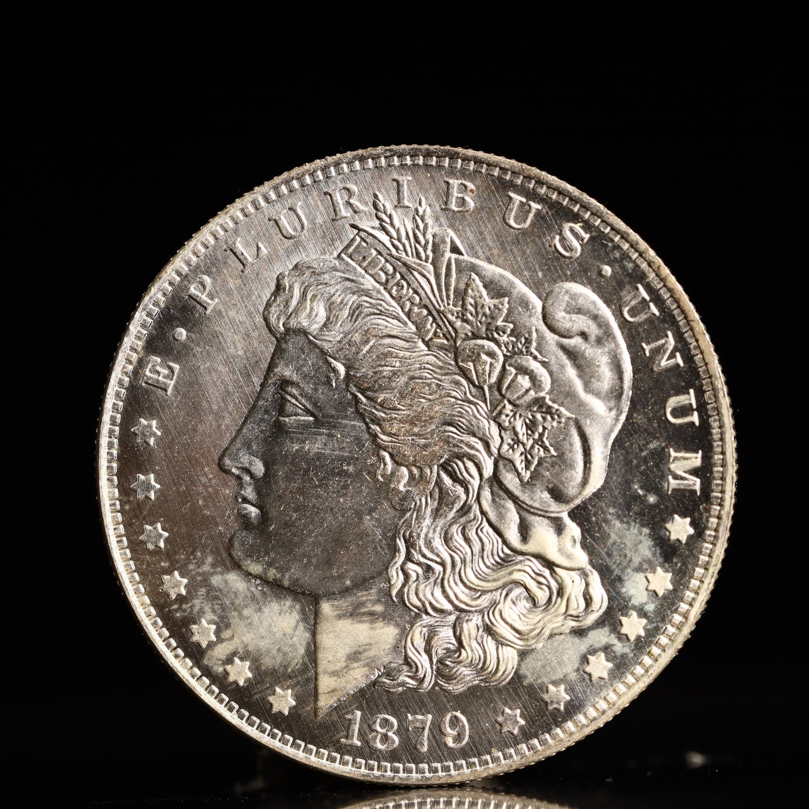 USA Morgan Dollar 1879 Coin: Obv: profile bust with date below and E PLURIBUS UNUM legend and stars around. Rev: eagle with In God we trust above within wreath with UNITED STATES OF AMERICA ONE DOLLAR legend. IN GOD WE TRUST / LI