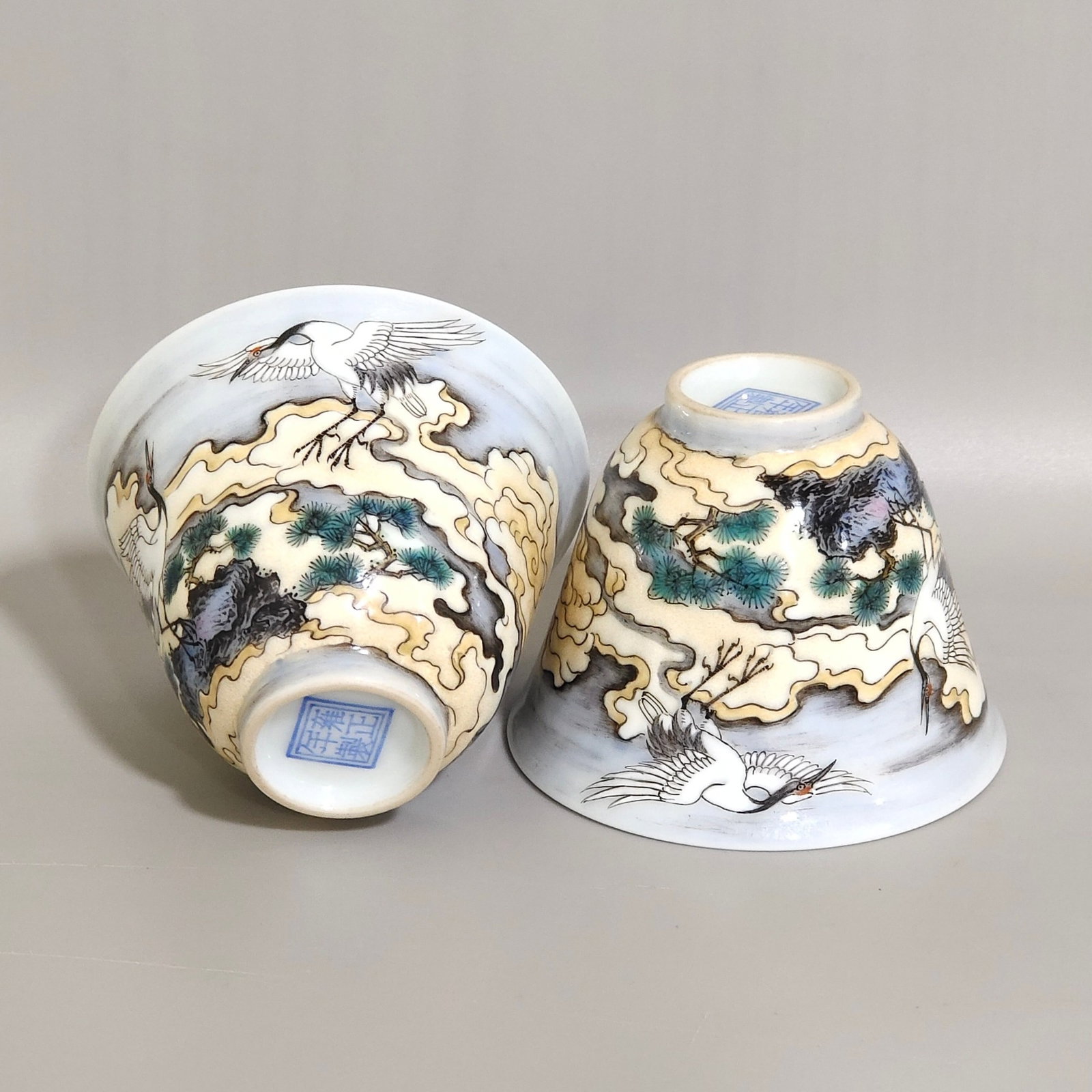 A Pair of Exquisite Famille-Rose Auspicious Cloud,Pine and Crane Pattern Cups: A Pair of Exquisite Famille-Rose Auspicious Cloud,Pine and Crane Pattern Cups,Qing Dynasty,China,Yongzheng Four-character Mark,Size:1.9inx2.4in