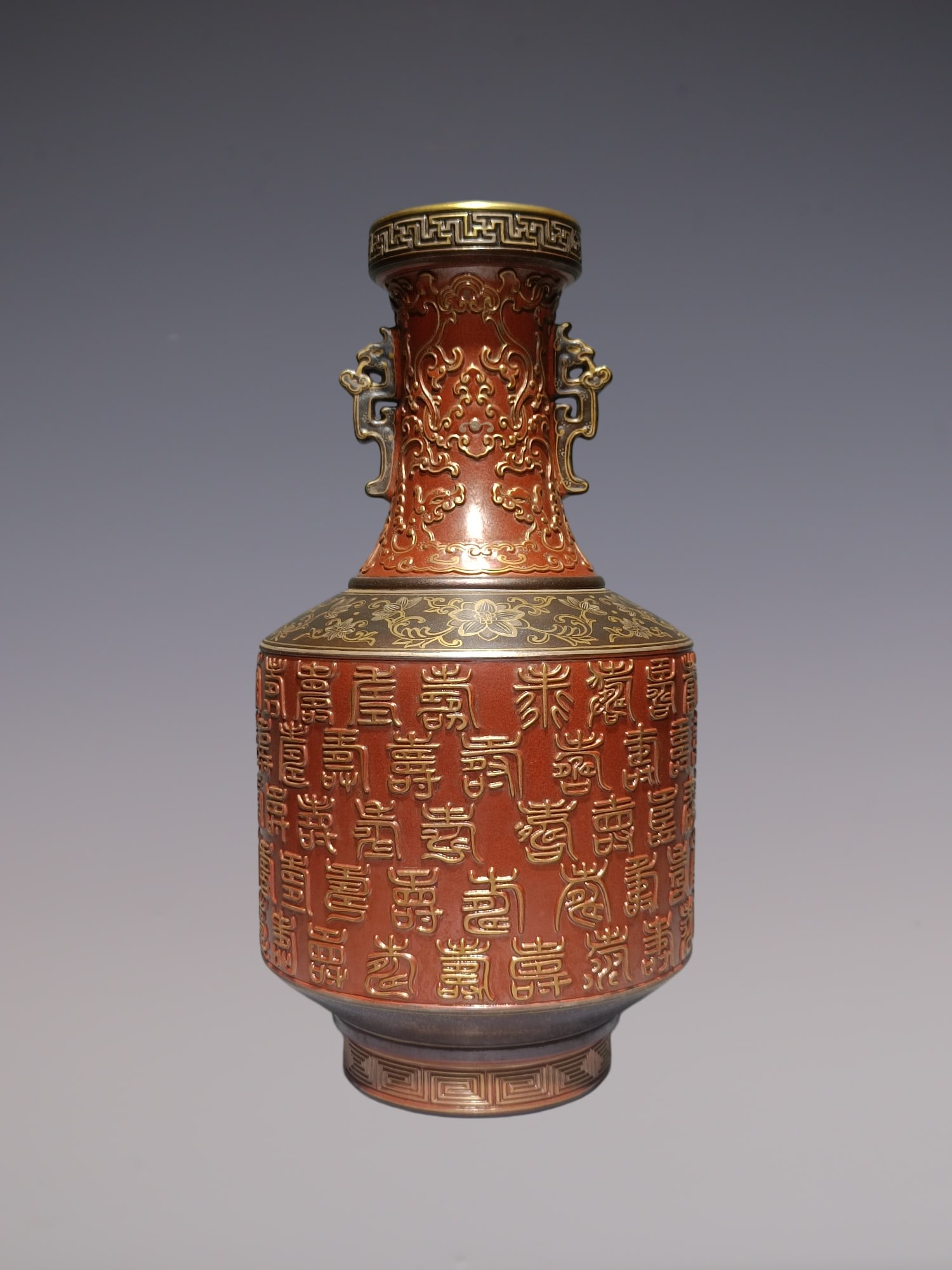 An Exquisite Iron-Red Painted Gold Lotus Pattern Double-Ears Vase: An Exquisite Iron-Red Painted Gold Lotus Pattern Double-Ears Vase Qing Dynasty, China Qianlong Six-character Mark Size:11.8inx6.1in古铜釉雕刻矾红描ŵ