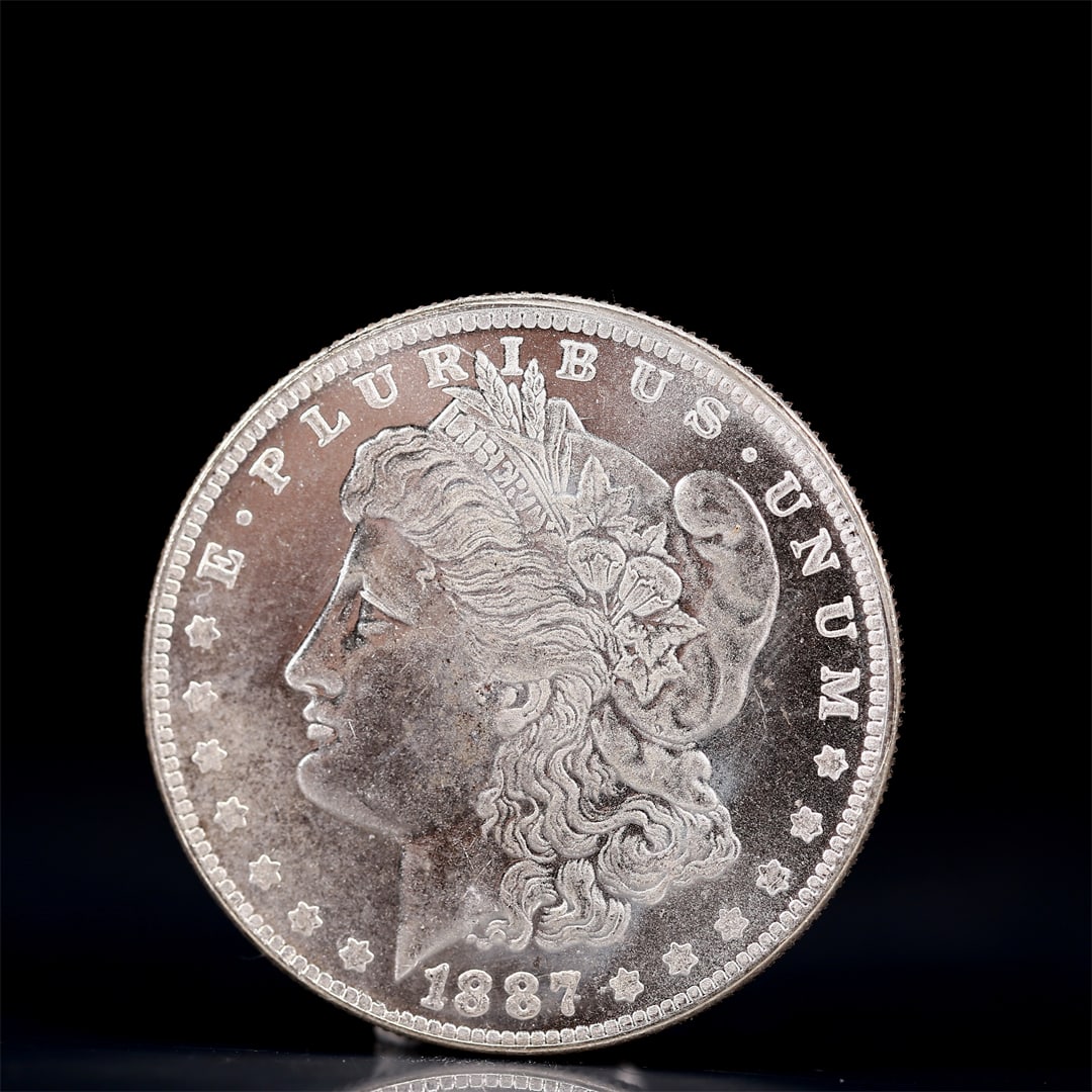 USA Morgan Dollar 1887 Coin: Obv: profile bust with date below and E PLURIBUS UNUM legend and stars around. Rev: eagle with In God we trust above within wreath with UNITED STATES OF AMERICA ONE DOLLAR legend. IN GOD WE TRUST / LI