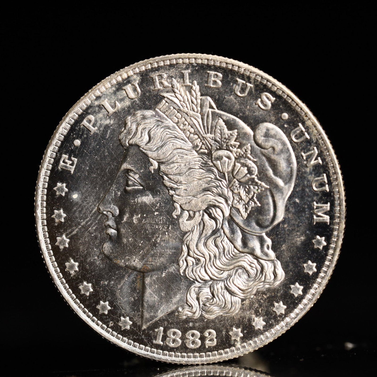 USA Morgan Dollar 1882 Coin: Obv: profile bust with date below and E PLURIBUS UNUM legend and stars around. Rev: eagle with In God we trust above within wreath with UNITED STATES OF AMERICA ONE DOLLAR legend. IN GOD WE TRUST / LI