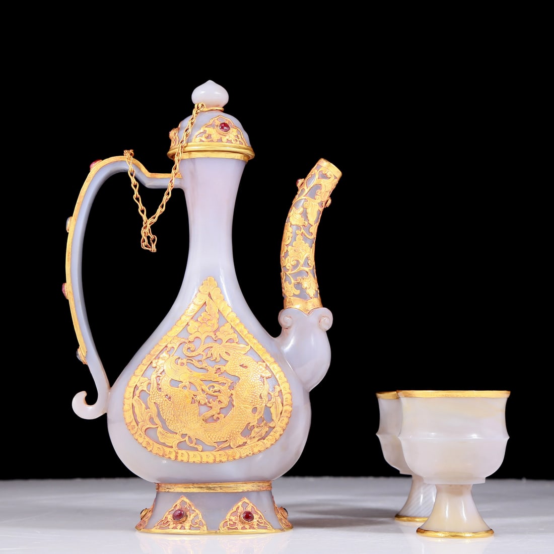 A set of exquisite agate gold-covered tea sets: Estimated Value:12000-26000 An exquisite agate gold-covered ewer with floral and dragon patterns, and two onyx gold-covered small cups, Qing Dynasty, China, Size: ewer: 5.5inx2.4inx9.4in, cup: