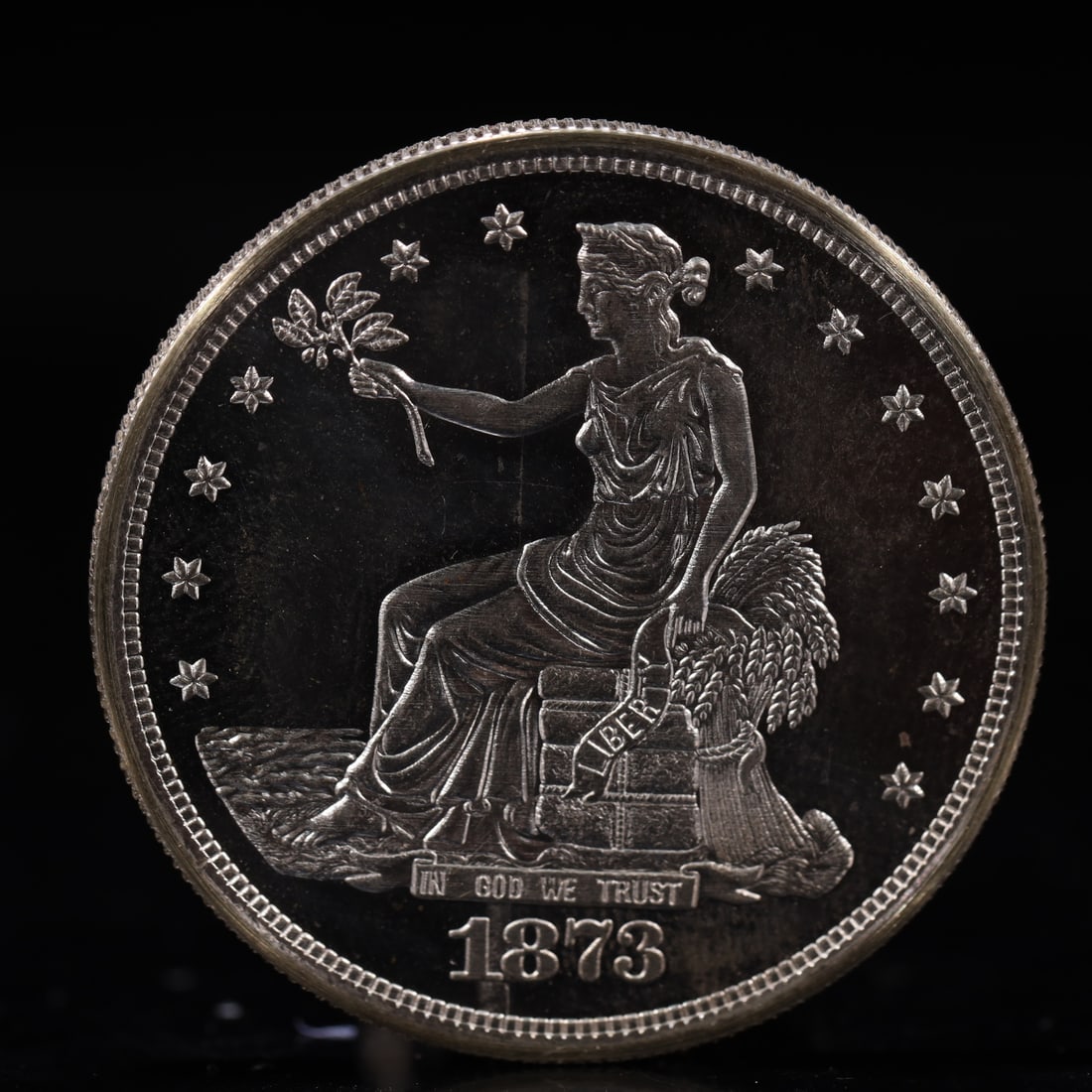 USA Trade Dollar 1873 Coin: American coin. Obverse: Liberty seated on a pedestal facing the sea to the left holding olive branches surrounded by 13 stars. IN GOD WE TRUST / LIBERTY / 1873. Reverse: An eagle holding branches with