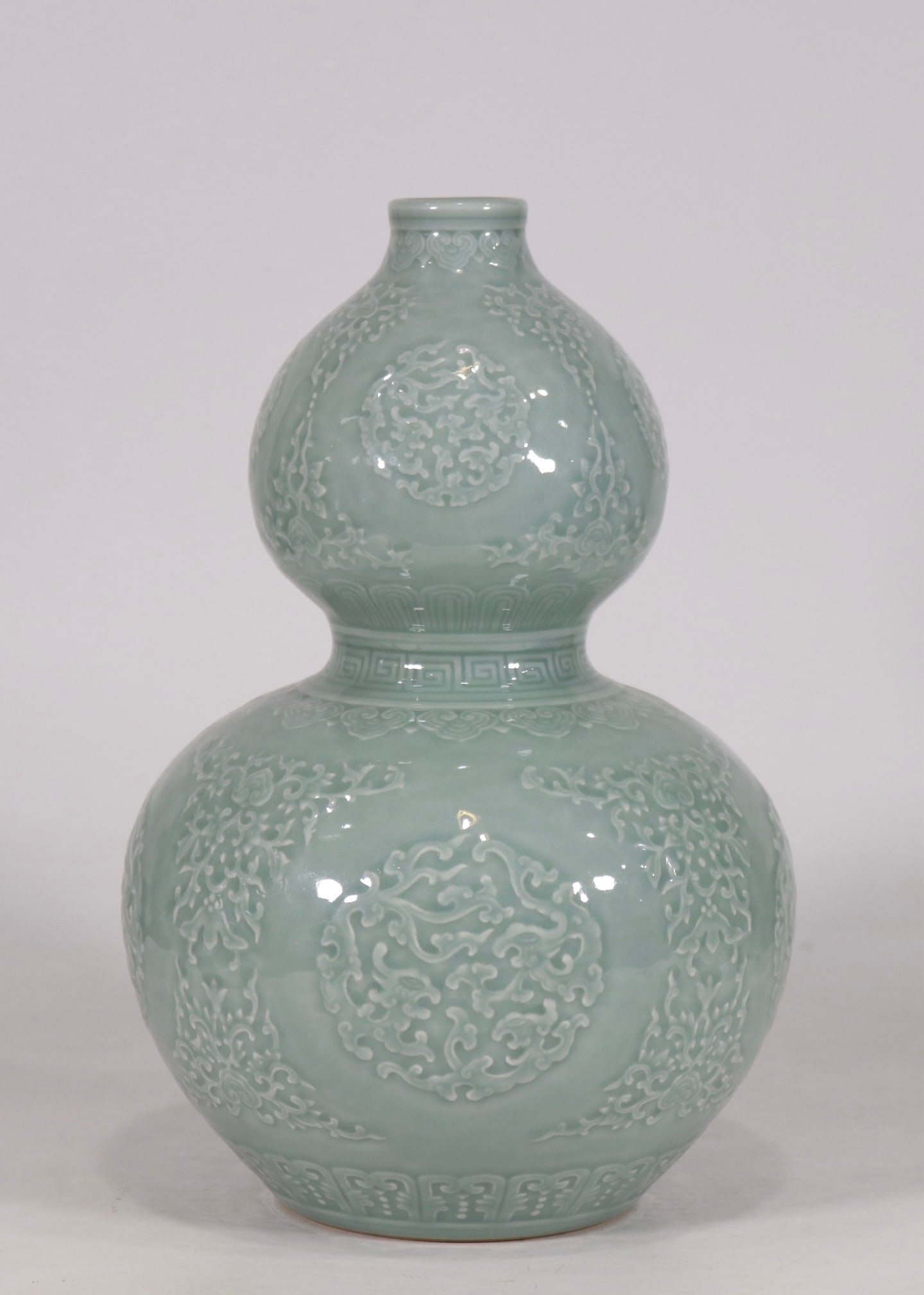 An Exquisite Celadon Glazed Dragon Pattern Gourd-Shaped Vase: An Exquisite Celadon Glazed Dragon Pattern Gourd-Shaped Vase Qing Dynasty, China Qianlong Six-character Mark Size:12.9inx8.3in豆青釉雕刻团龙纹葫&#