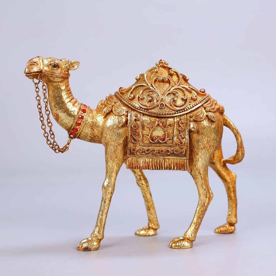 An Exquisite Gilt Bronze Inlaid Gems Camel Ornament: An Exquisite Gilt Bronze Inlaid Gems Camel Ornament Qing Dynasty, China Size:5.5inx7.1in Weight:578g铜鎏金镶嵌宝石骆驼摆件