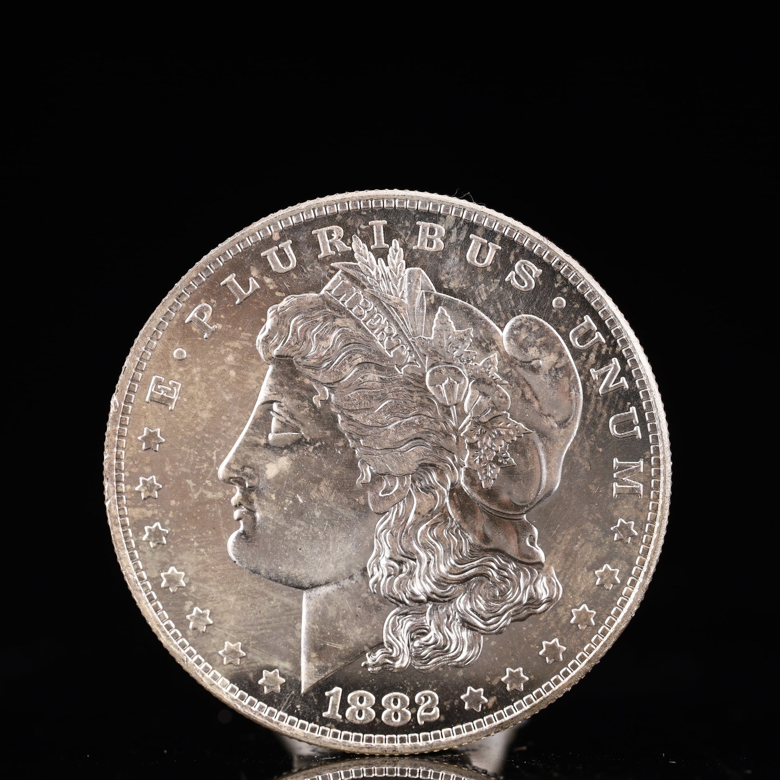USA Morgan Dollar 1882 Coin: Obv: profile bust with date below and E PLURIBUS UNUM legend and stars around. Rev: eagle with In God we trust above within wreath with UNITED STATES OF AMERICA ONE DOLLAR legend. IN GOD WE TRUST / LI