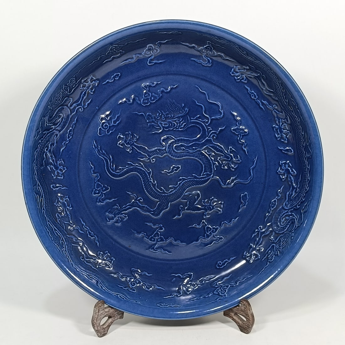 An Exquisite Blue Glazed Dragon Pattern Plate: An Exquisite Blue Glazed Dragon Pattern Plate Ming Dynasty, China Size:2.6inx14.6in蓝釉雕刻龙纹盘 中国明代 Size:6.6cmx37cm