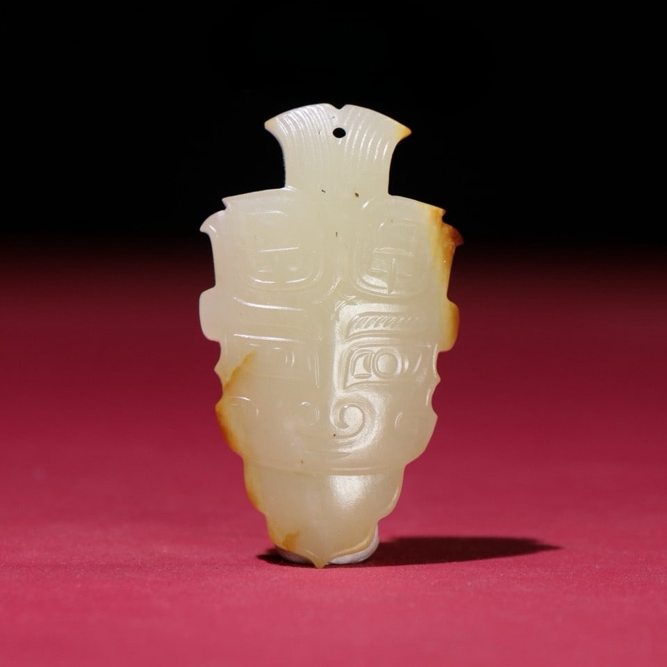 An Exquisite White Jade Human face Pattern Ornament: An Exquisite White Jade Human face Pattern Ornament Han Dynasty, China Size:2.3inx1.3inx0.4in Weight:25g白玉神人首挂饰 中国汉代