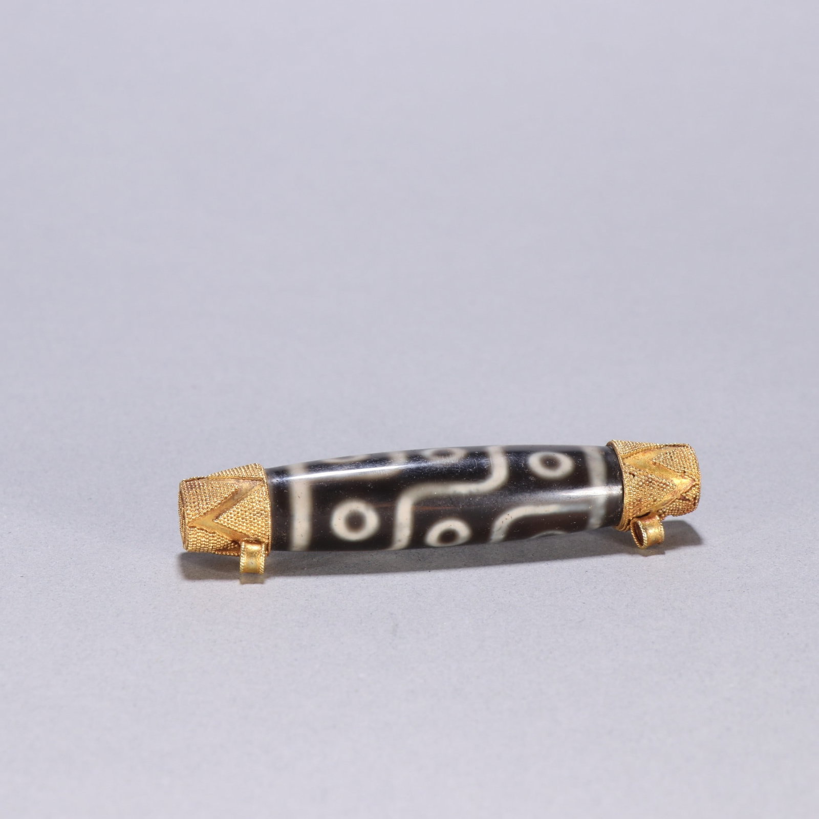 An Exquisite Dzi Bead Ornament: An Exquisite Dzi Bead Ornament Qing Dynasty, China Size:3.1inx0.6in Weight:32.5g天珠摆件 中国清代 Size:7.9cmx1.5cm Weight:32.5g