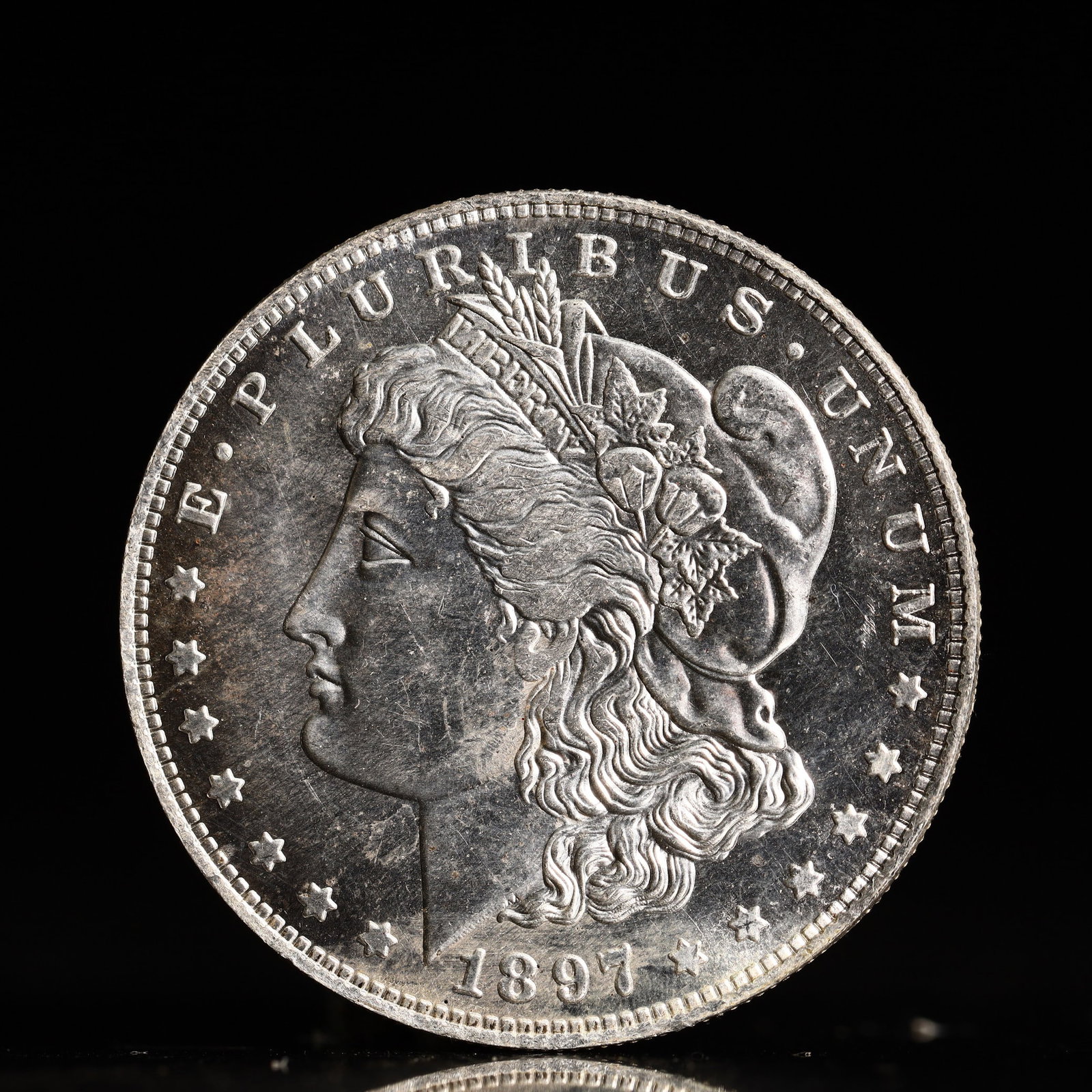 USA Morgan Dollar 1897 Coin: Obv: profile bust with date below and E PLURIBUS UNUM legend and stars around. Rev: eagle with In God we trust above within wreath with UNITED STATES OF AMERICA ONE DOLLAR legend. IN GOD WE TRUST / LI