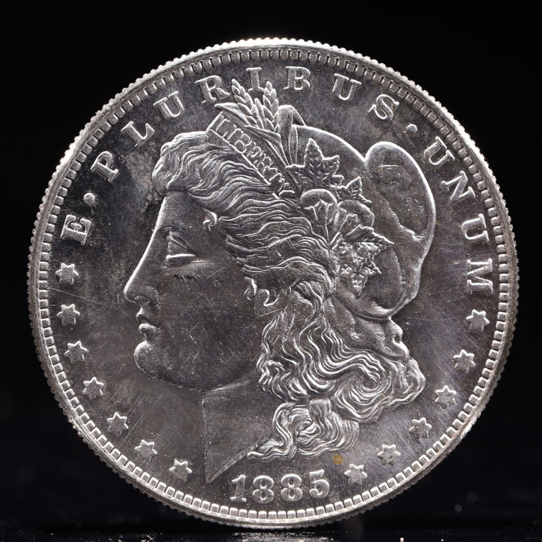 USA Morgan Dollar 1885 Coin: Obv: profile bust with date below and E PLURIBUS UNUM legend and stars around. Rev: eagle with In God we trust above within wreath with UNITED STATES OF AMERICA ONE DOLLAR legend. IN GOD WE TRUST / LI