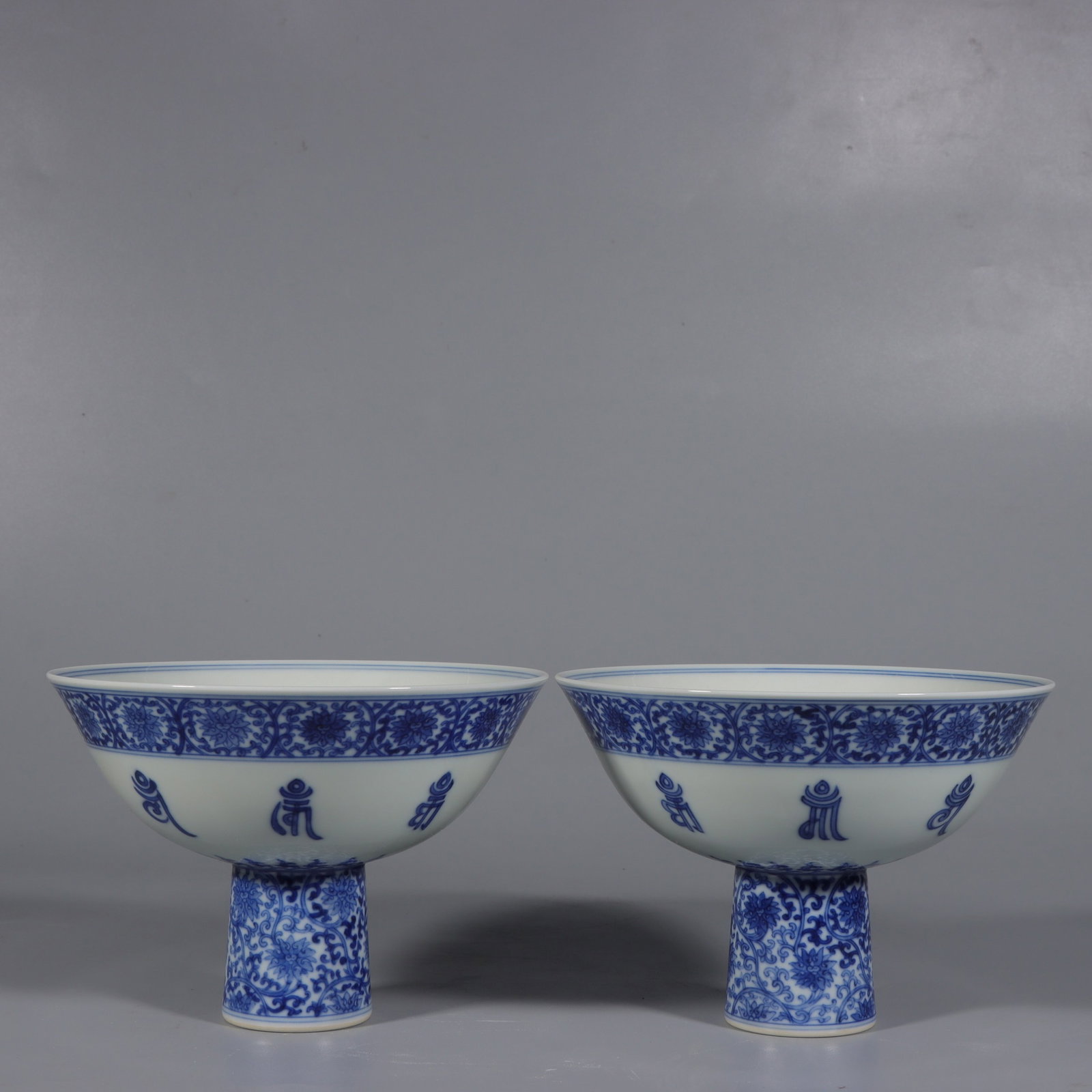 A Pair of Exquisite Blue and White Lotus Pattern Stem Bowls,With Sanskrit: A Pair of Exquisite Blue and White Lotus Pattern Stem Bowls,With Sanskrit,Qing Dynasty,China,Yongzheng Six-character Mark,Size:4.2inx6.3in