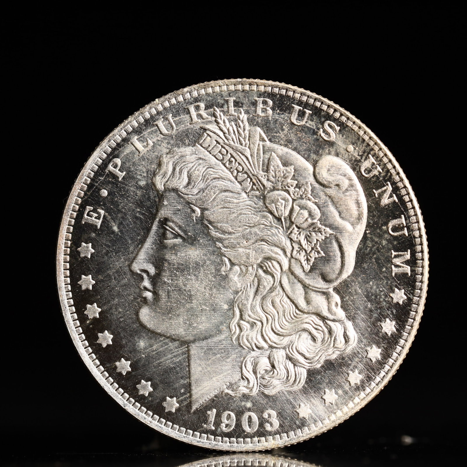 USA Morgan Dollar 1903 Coin: Obv: profile bust with date below and E PLURIBUS UNUM legend and stars around. Rev: eagle with In God we trust above within wreath with UNITED STATES OF AMERICA ONE DOLLAR legend. IN GOD WE TRUST /