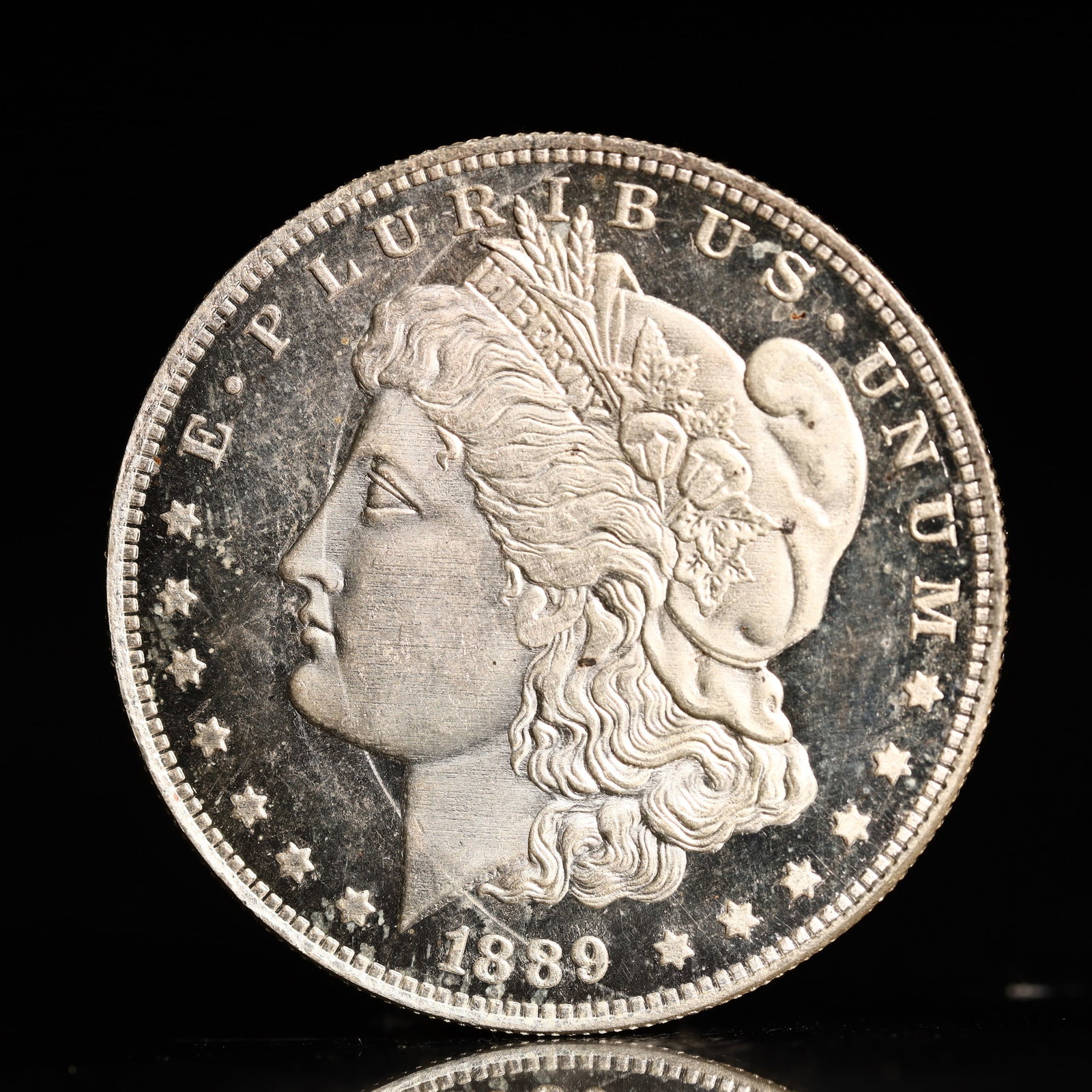 USA Morgan Dollar 1889 Coin: Obv: profile bust with date below and E PLURIBUS UNUM legend and stars around. Rev: eagle with In God we trust above within wreath with UNITED STATES OF AMERICA ONE DOLLAR legend. IN GOD WE TRUST /