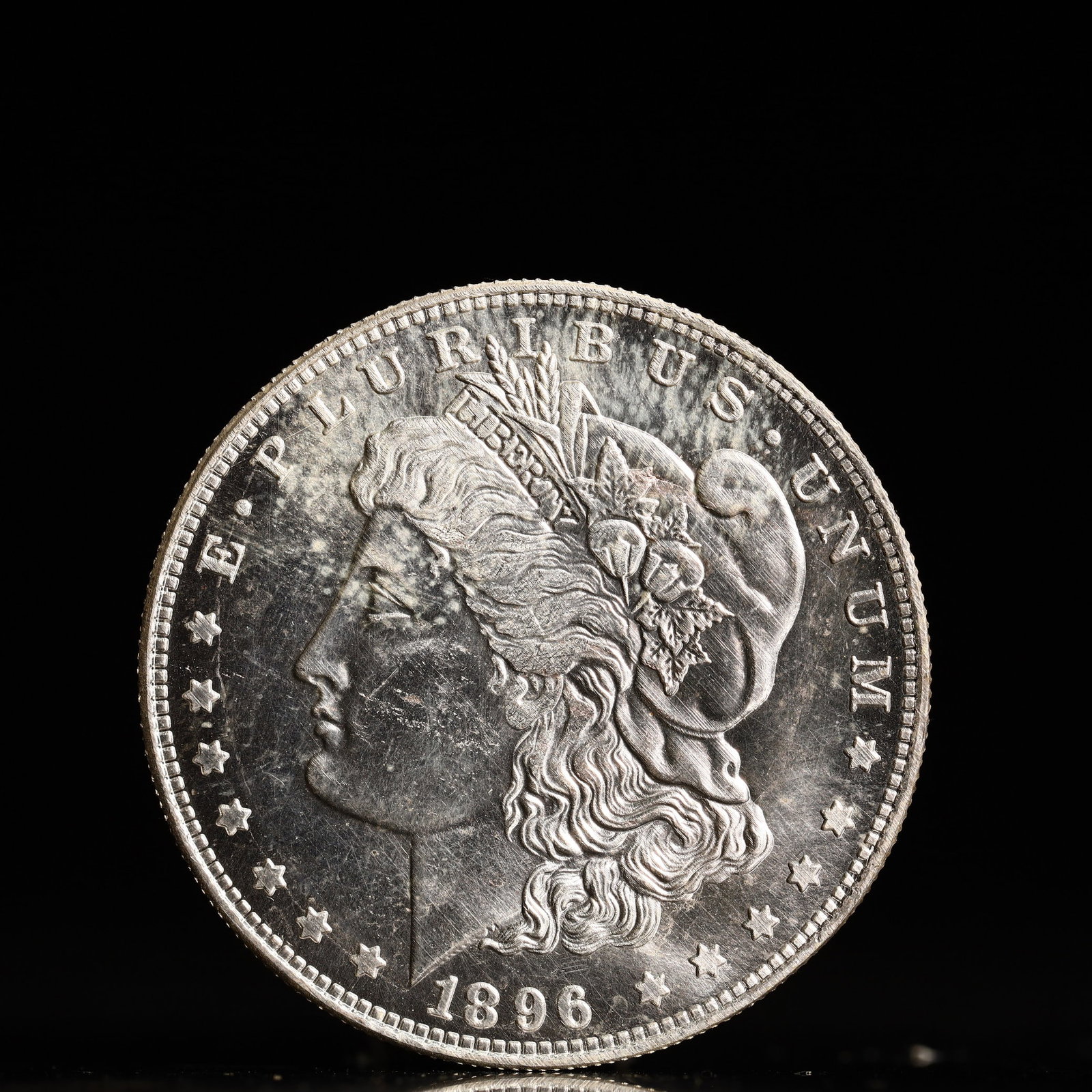 USA Morgan Dollar 1896 Coin: Obv: profile bust with date below and E PLURIBUS UNUM legend and stars around. Rev: eagle with In God we trust above within wreath with UNITED STATES OF AMERICA ONE DOLLAR legend. IN GOD WE TRUST / LI