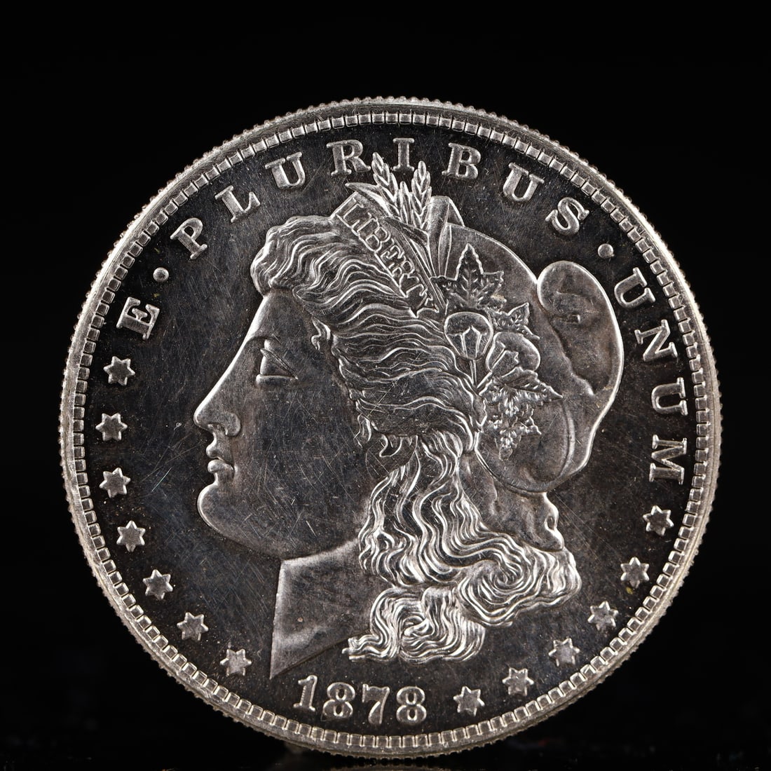 USA Morgan Dollar 1878 Coin: Obv: profile bust with date below and E PLURIBUS UNUM legend and stars around. Rev: eagle with In God we trust above within wreath with UNITED STATES OF AMERICA ONE DOLLAR legend. IN GOD WE TRUST / LI