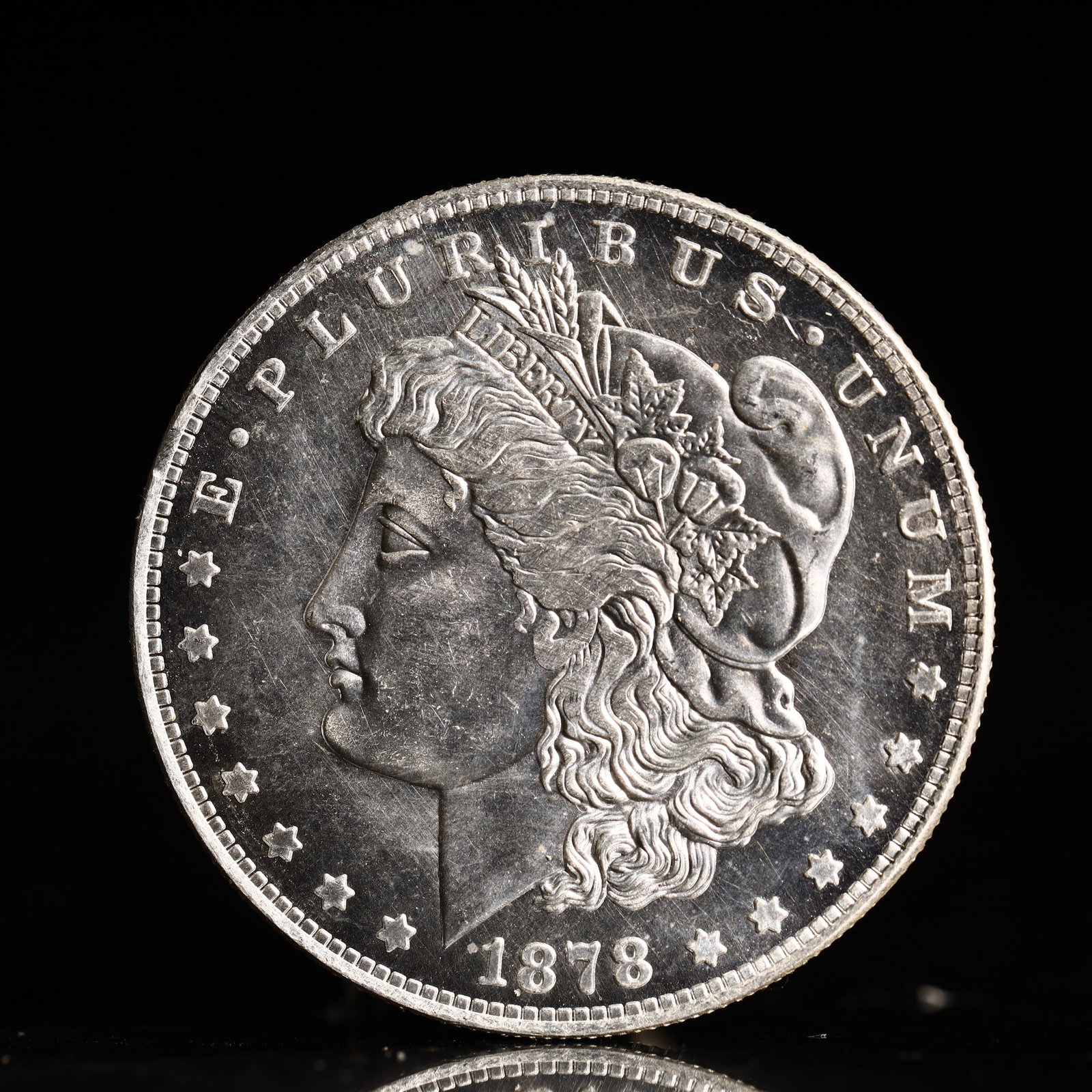 USA Morgan Dollar 1878 Coin: Obv: profile bust with date below and E PLURIBUS UNUM legend and stars around. Rev: eagle with In God we trust above within wreath with UNITED STATES OF AMERICA ONE DOLLAR legend. IN GOD WE TRUST / LI