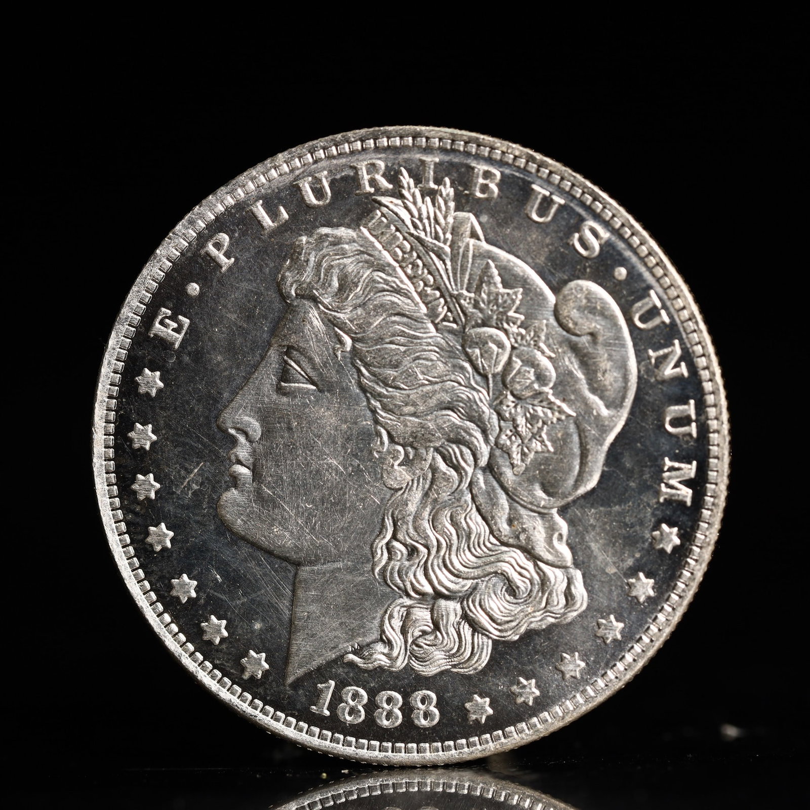 USA Morgan Dollar 1888 Coin: Obv: profile bust with date below and E PLURIBUS UNUM legend and stars around. Rev: eagle with In God we trust above within wreath with UNITED STATES OF AMERICA ONE DOLLAR legend. IN GOD WE TRUST / LI