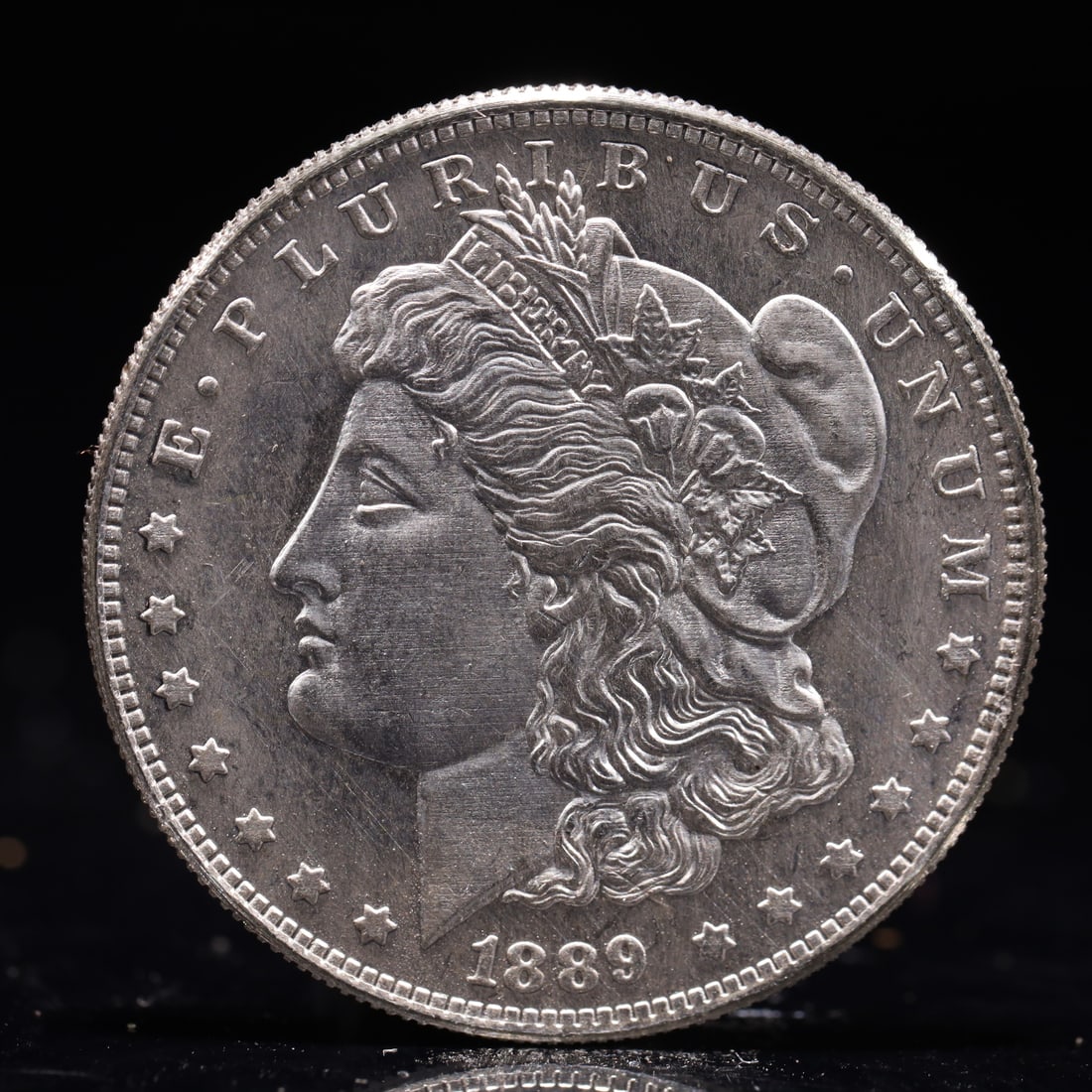 USA Morgan Dollar 1889 Coin: Obv: profile bust with date below and E PLURIBUS UNUM legend and stars around. Rev: eagle with In God we trust above within wreath with UNITED STATES OF AMERICA ONE DOLLAR legend. IN GOD WE TRUST / LI