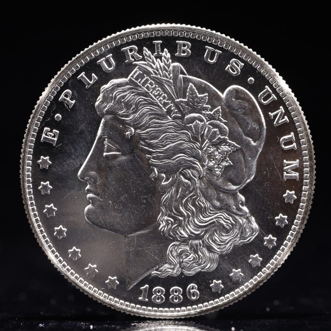 USA Morgan Dollar 1886 Coin: Obv: profile bust with date below and E PLURIBUS UNUM legend and stars around. Rev: eagle with In God we trust above within wreath with UNITED STATES OF AMERICA ONE DOLLAR legend. IN GOD WE TRUST / LI