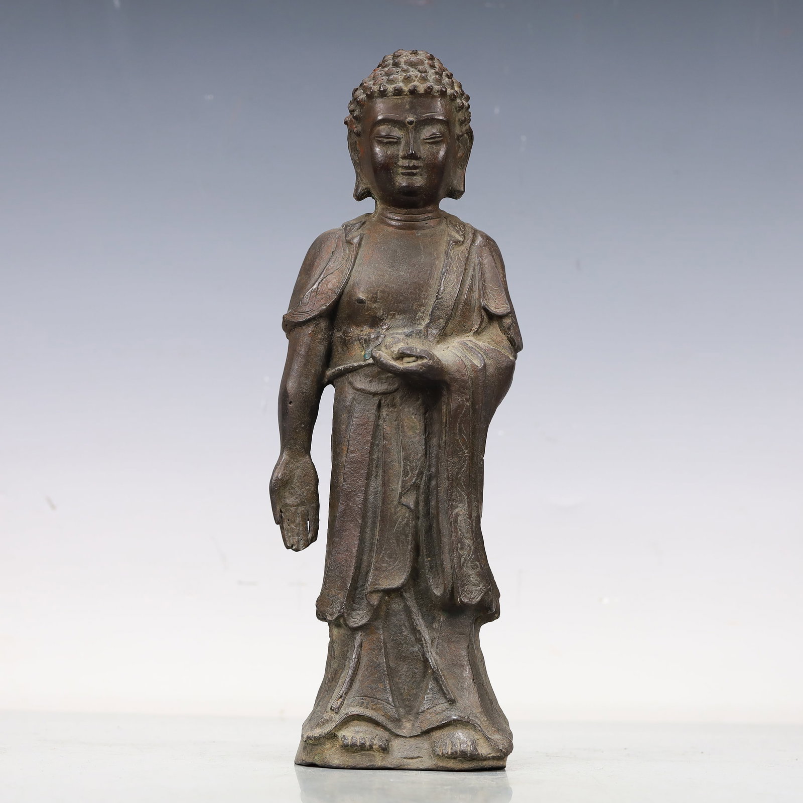 A Fabulous Bronze Figure Of Buddha Shakyamuni: A Fabulous Bronze Figure Of Buddha Shakyamuni. Stood,hair cast with ringlet curls,body rendered clad in long,flowing robes,the voluminous drapery elegantly cascading in folds. Chinese Ming Dynasty. Ji