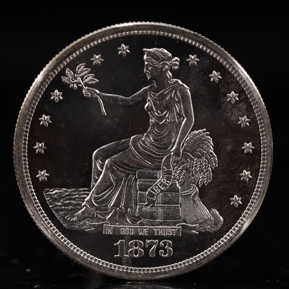 USA Trade Dollar 1873 Coin: American coin. Obverse: Liberty seated on a pedestal facing the sea to the left holding olive branches surrounded by 13 stars. IN GOD WE TRUST / LIBERTY / 1873. Reverse: An eagle holding branches with