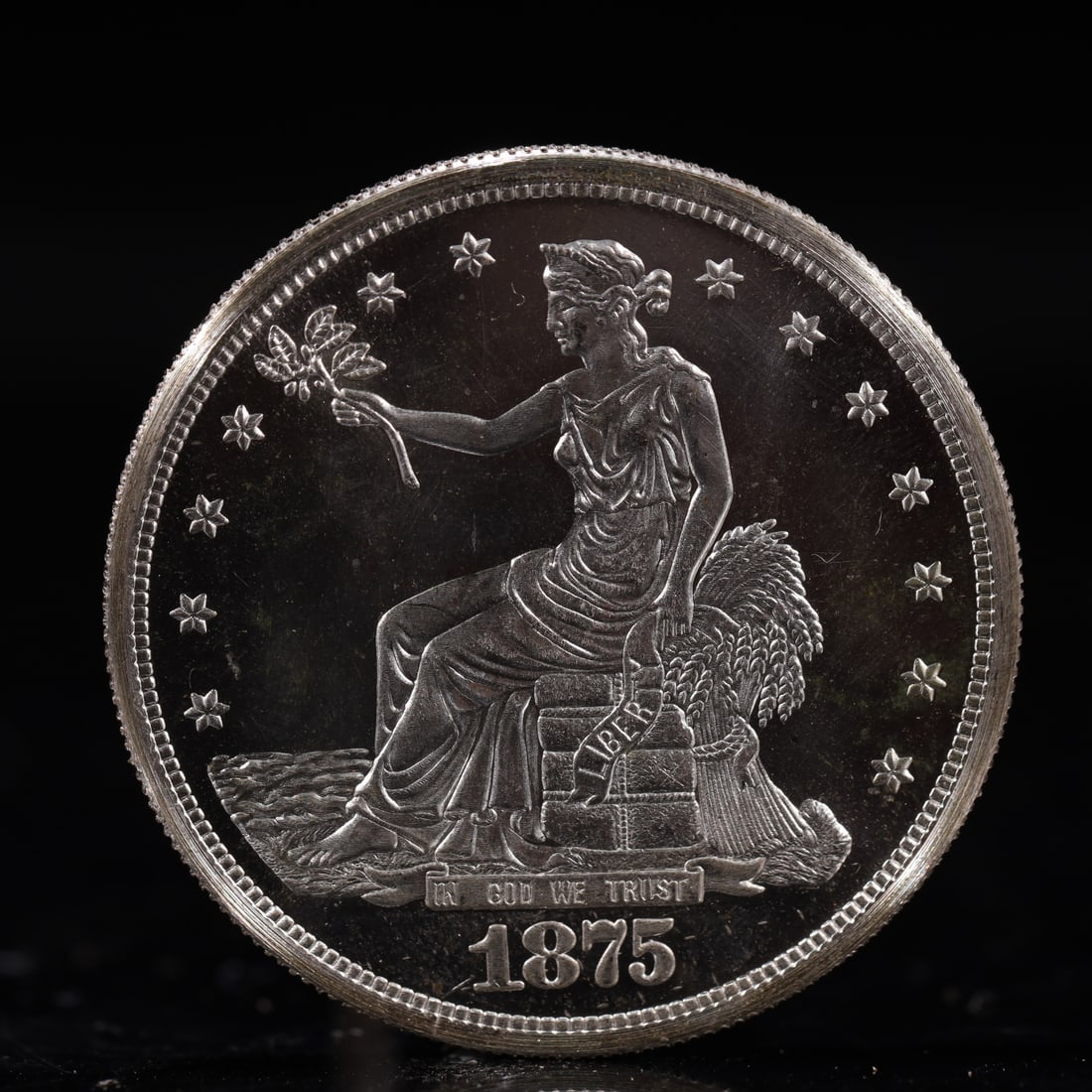 USA Trade Dollar 1875 Coin: American coin. Obverse: Liberty seated on a pedestal facing the sea to the left holding olive branches surrounded by 13 stars. IN GOD WE TRUST / LIBERTY / 1875. Reverse: An eagle holding branches with