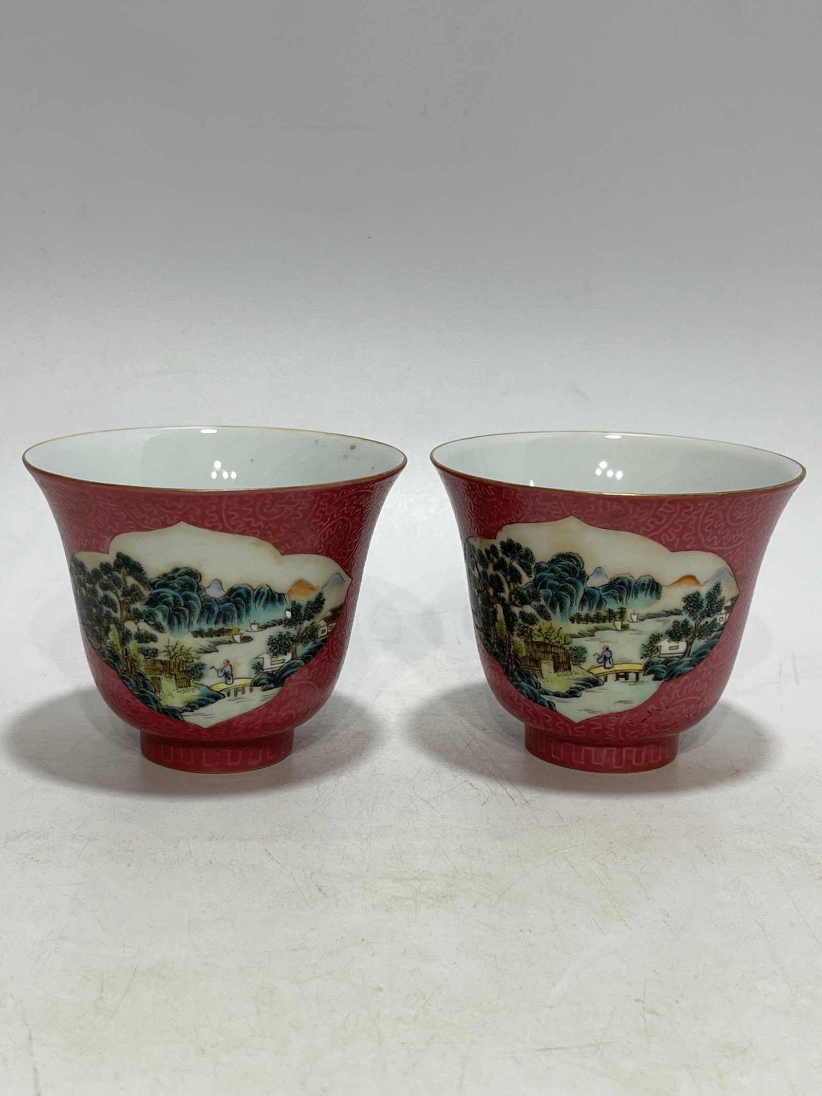 A Pair of Exquisite Famille-Rose Red Ground Landscape and Figure Pattern Cups: A Pair of Exquisite Famille-Rose Red Ground Landscape and Figure Pattern Cups,Qing Dynasty,China,Xianfeng Six-character Mark,Size:3.6in 一对粉彩红地山水