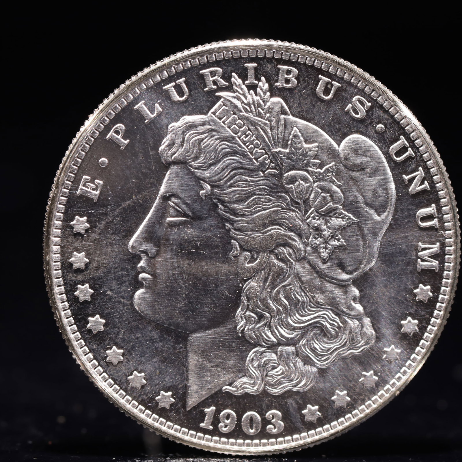 USA Morgan Dollar 1903 Coin: Obv: profile bust with date below and E PLURIBUS UNUM legend and stars around. Rev: eagle with In God we trust above within wreath with UNITED STATES OF AMERICA ONE DOLLAR legend. IN GOD WE TRUST /