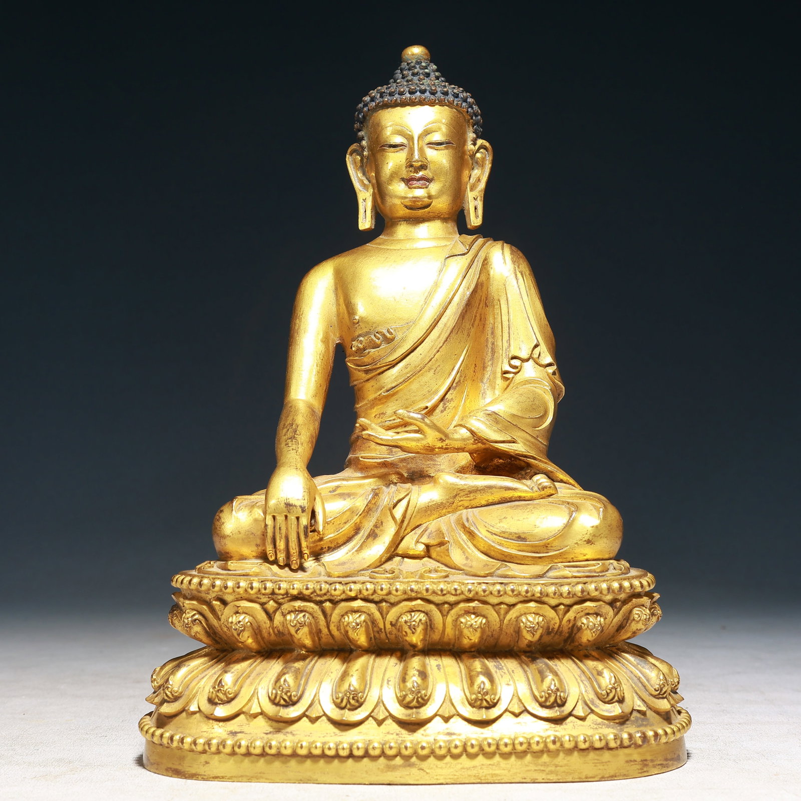A Solemn Gilt Bronze Statue of Sakyamuni: A Solemn Gilt Bronze Statue of Sakyamuni,Qing Dynasty,China,Size:7.1inx4.7inx10.2in,Weight:3050g 铜鎏金释迦摩尼像,中国清代