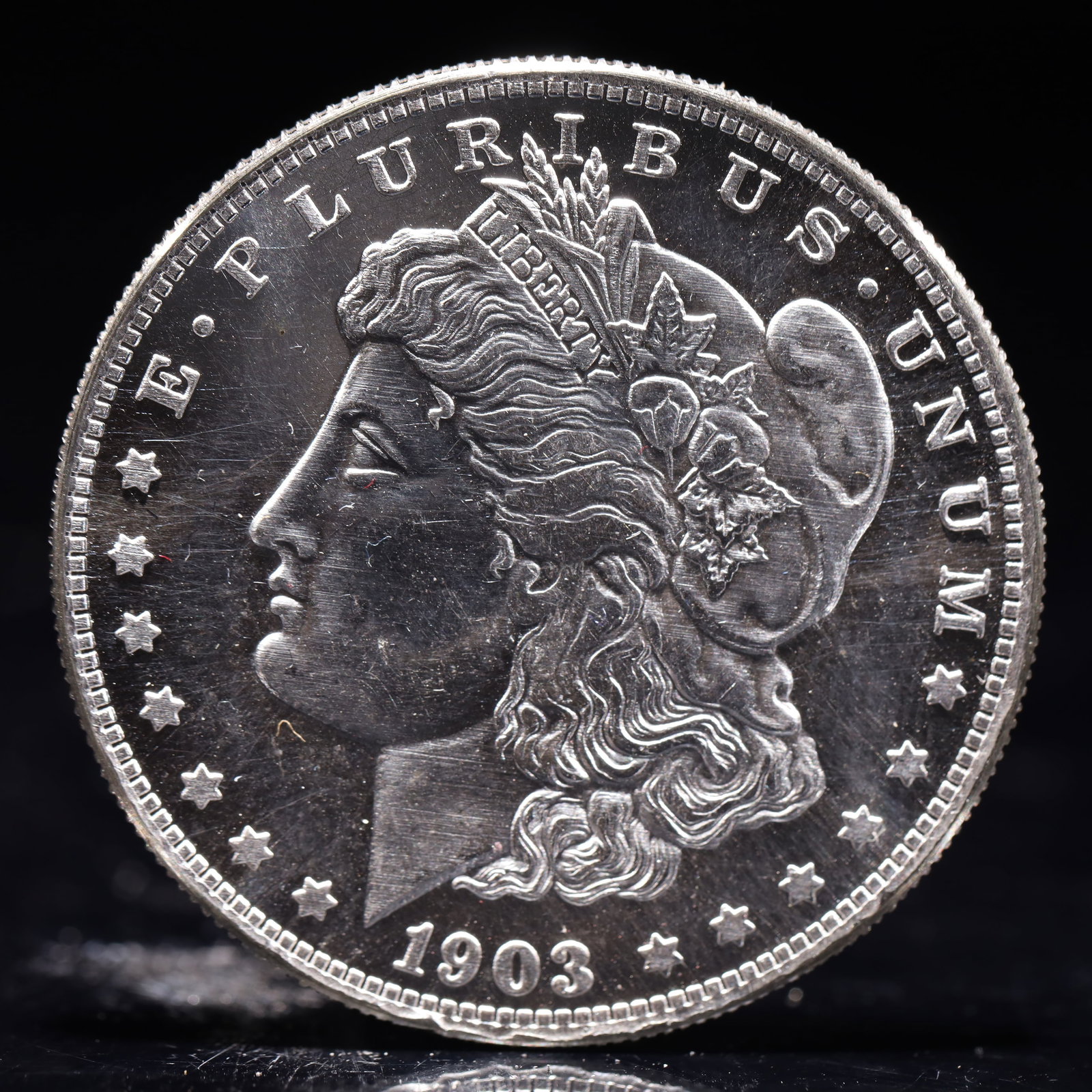 USA Morgan Dollar 1903 Coin: Obv: profile bust with date below and E PLURIBUS UNUM legend and stars around. Rev: eagle with In God we trust above within wreath with UNITED STATES OF AMERICA ONE DOLLAR legend. IN GOD WE TRUST / LI