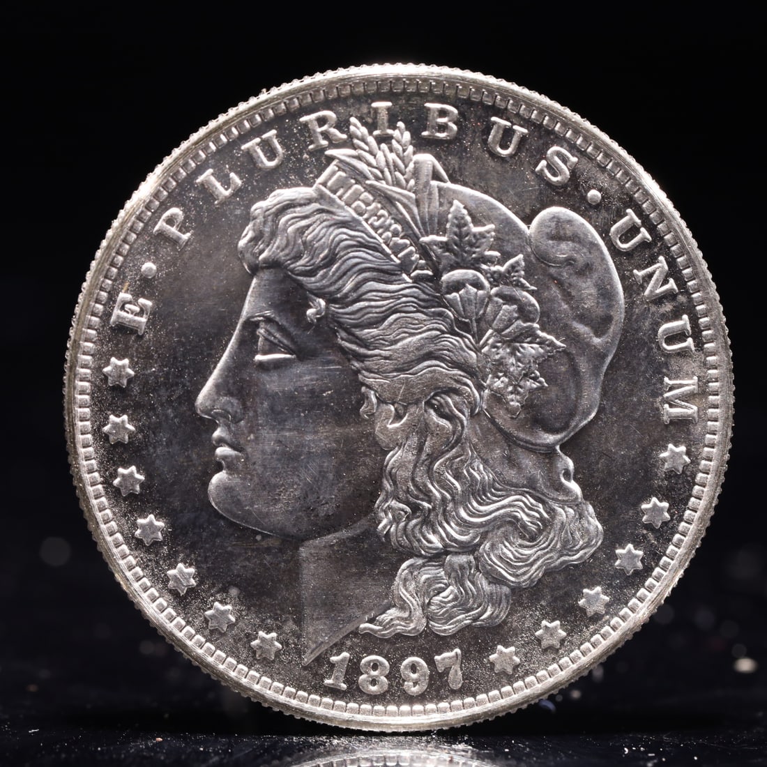 USA Morgan Dollar 1897 Coin: Obv: profile bust with date below and E PLURIBUS UNUM legend and stars around. Rev: eagle with In God we trust above within wreath with UNITED STATES OF AMERICA ONE DOLLAR legend. IN GOD WE TRUST / LI
