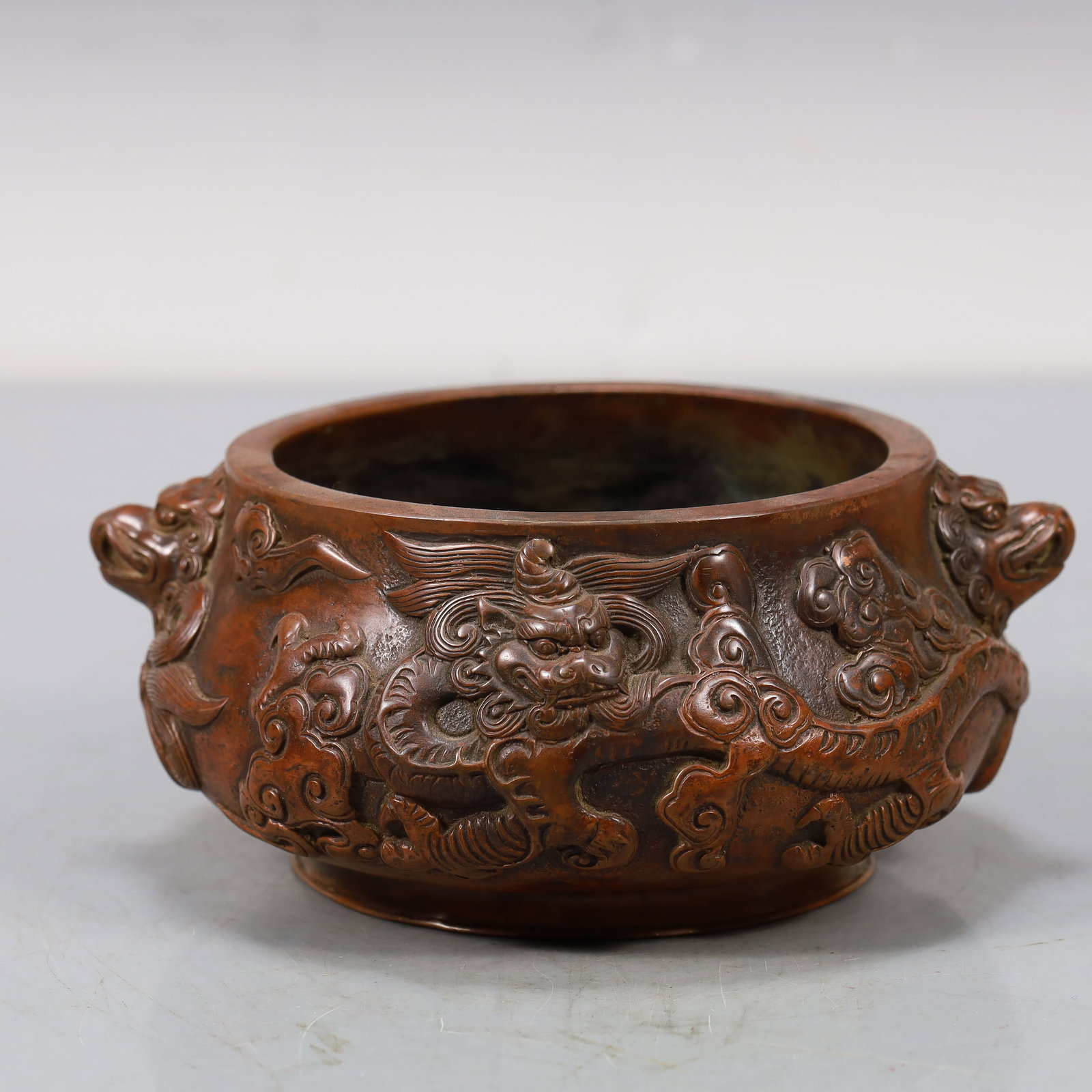 An Elaborate Bronze 'Dragon& Auspicious Cloud' Lion-Handled Censer: An Elaborate Bronze 'Dragon& Auspicious Cloud' Lion-Handled Censer. Of compressed form,body cast with scaly,sinuous dragons writhing amidst dense,scrolling clouds,all supported on a subtly splayed