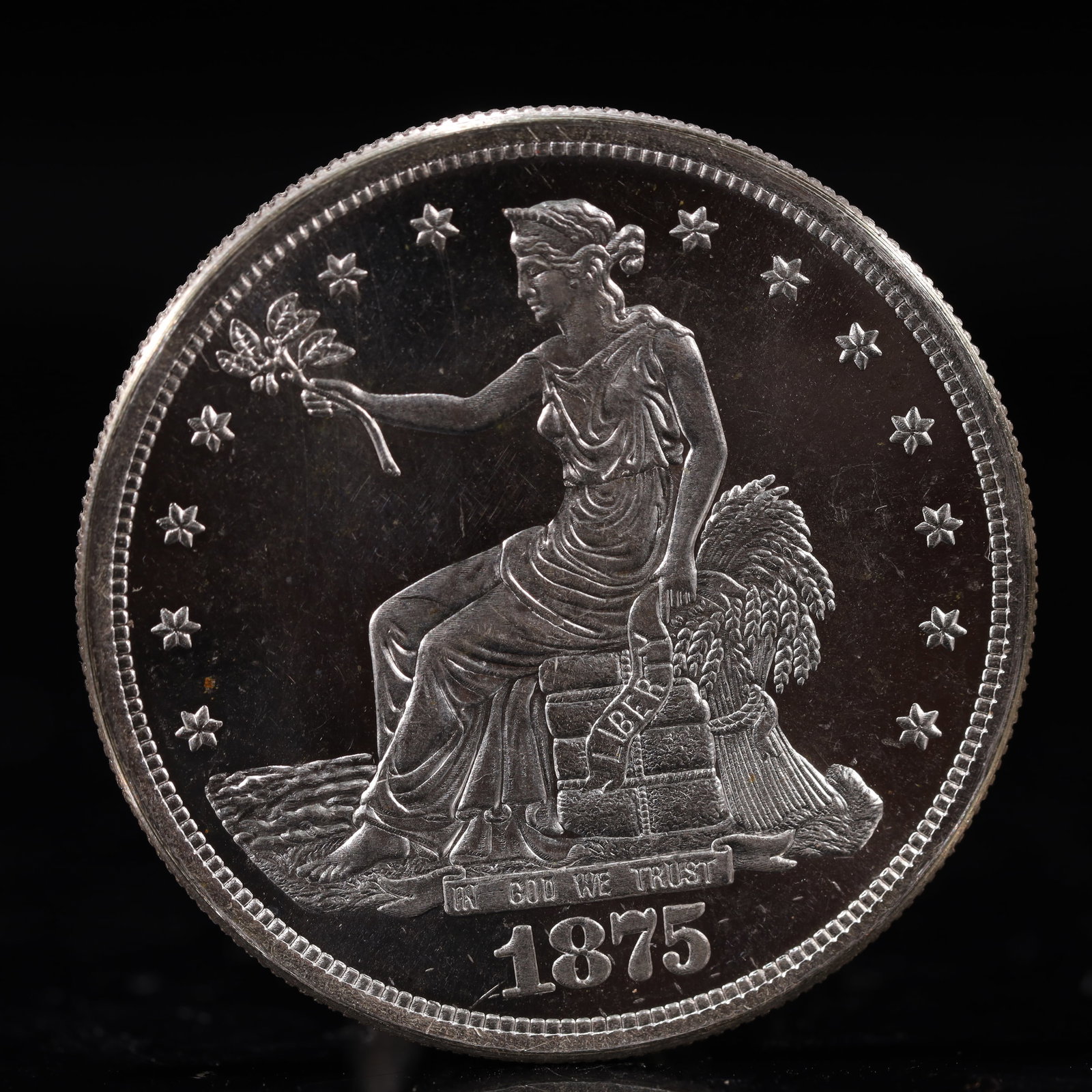 USA Trade Dollar 1875 Coin: American coin. Obverse: Liberty seated on a pedestal facing the sea to the left holding olive branches surrounded by 13 stars. IN GOD WE TRUST / LIBERTY / 1875. Reverse: An eagle holding branches with