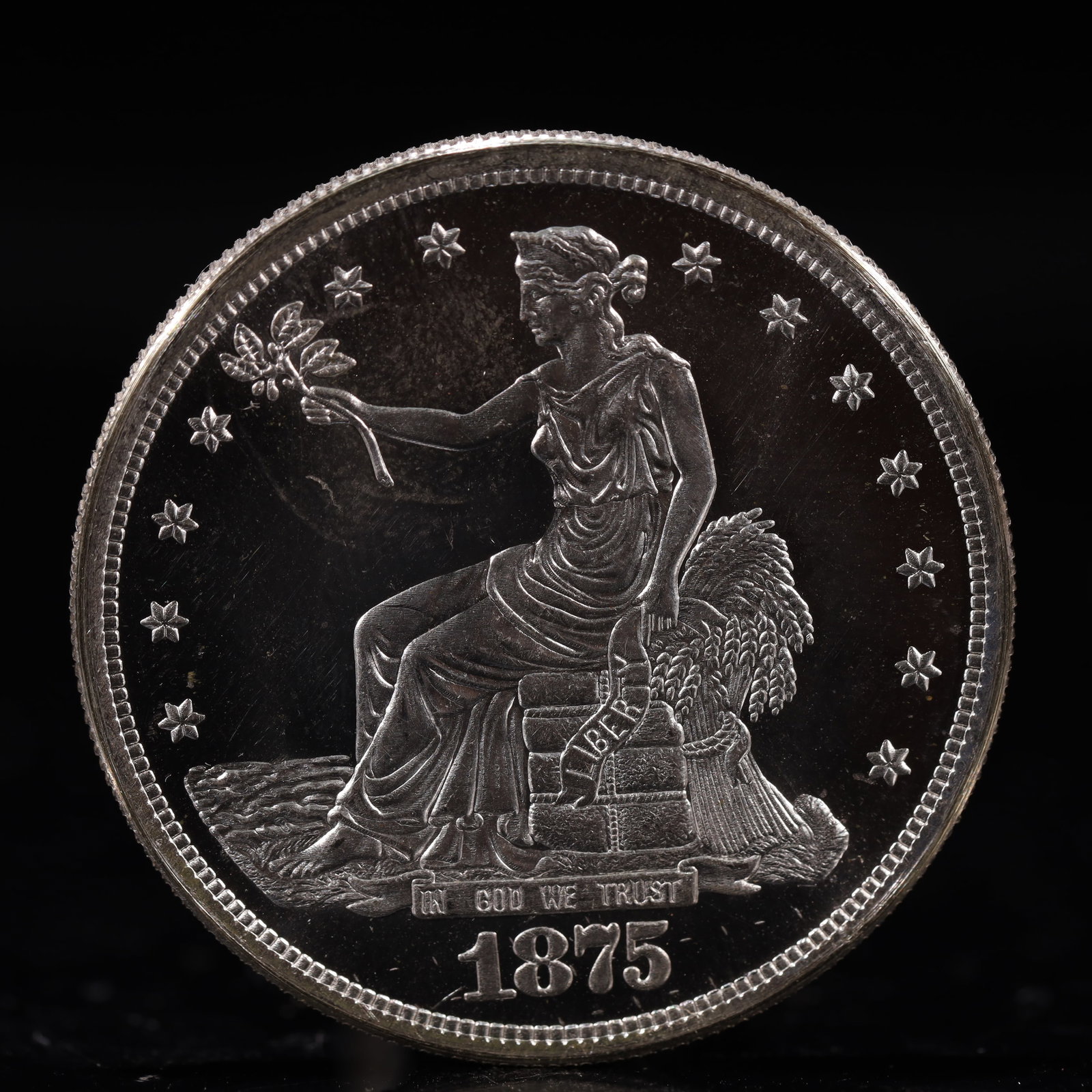 USA Trade Dollar 1875 Coin: American coin. Obverse: Liberty seated on a pedestal facing the sea to the left holding olive branches surrounded by 13 stars. IN GOD WE TRUST / LIBERTY / 1875. Reverse: An eagle holding branches with