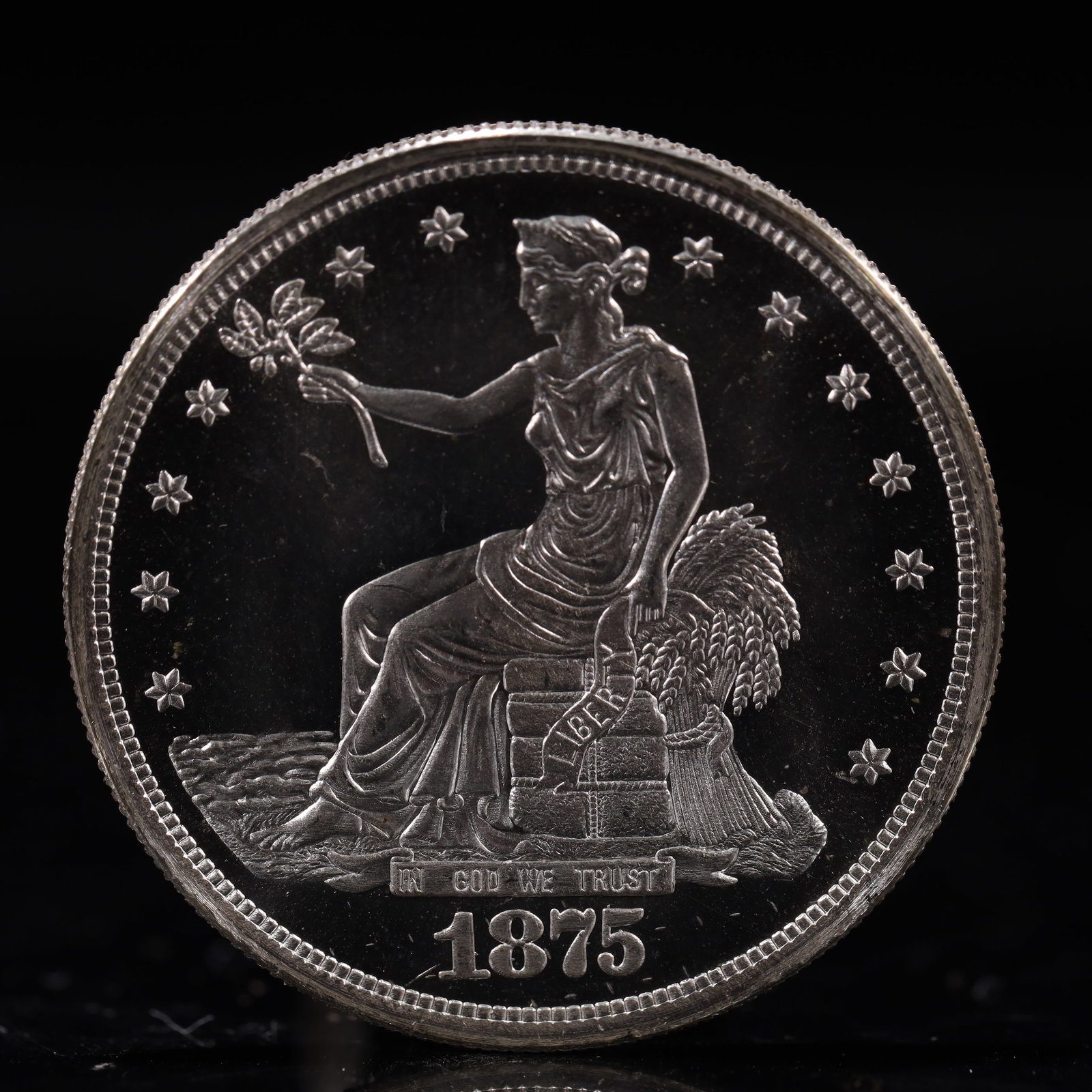 USA Trade Dollar 1875 Coin: American coin. Obverse: Liberty seated on a pedestal facing the sea to the left holding olive branches surrounded by 13 stars. IN GOD WE TRUST / LIBERTY / 1875. Reverse: An eagle holding branches with